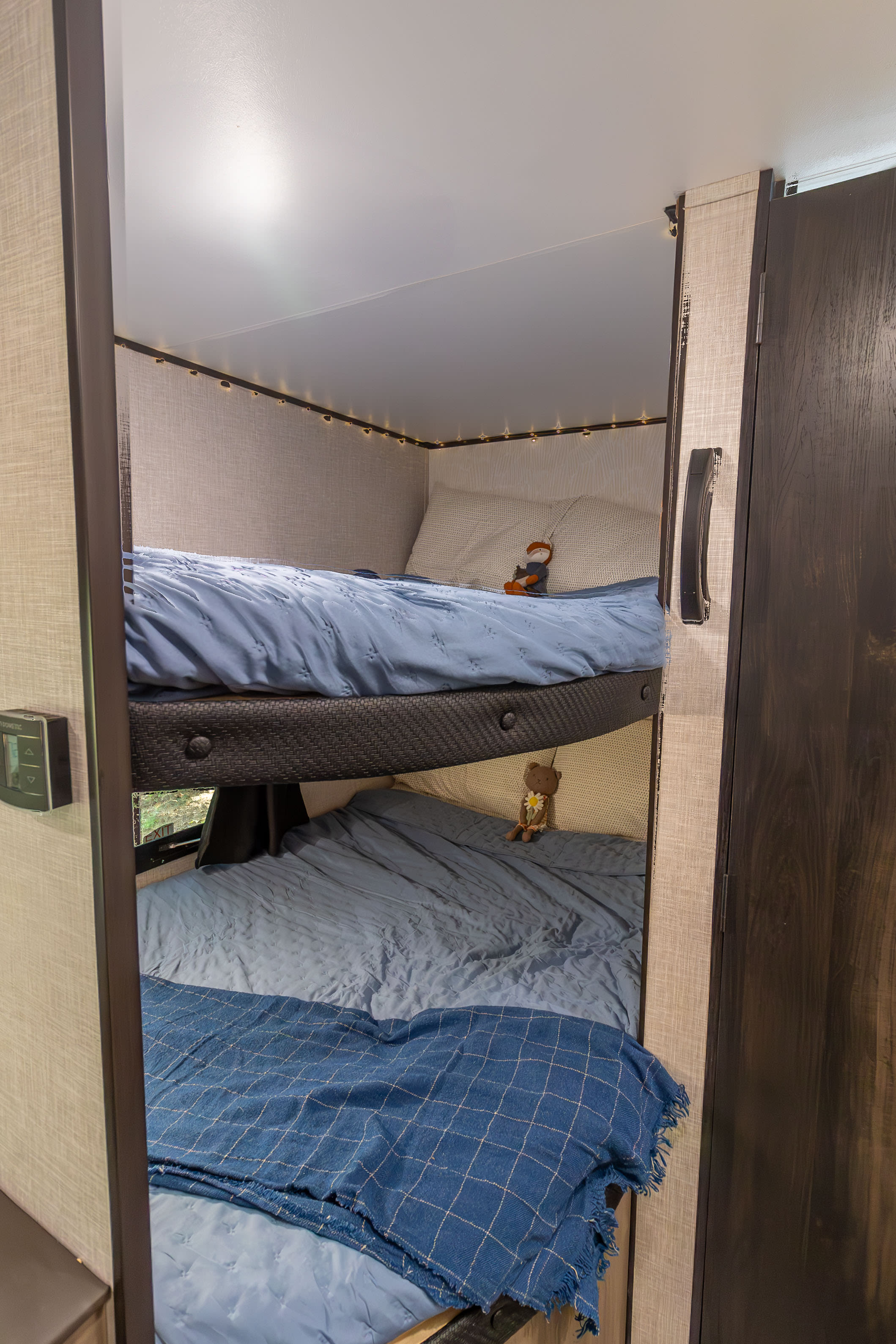 Cozy RV rental features two stacked bunk beds with blue bedding, complete with cute stuffed animals. A comfortable sleeping area.. Jayco Jay Flight SLX 2024