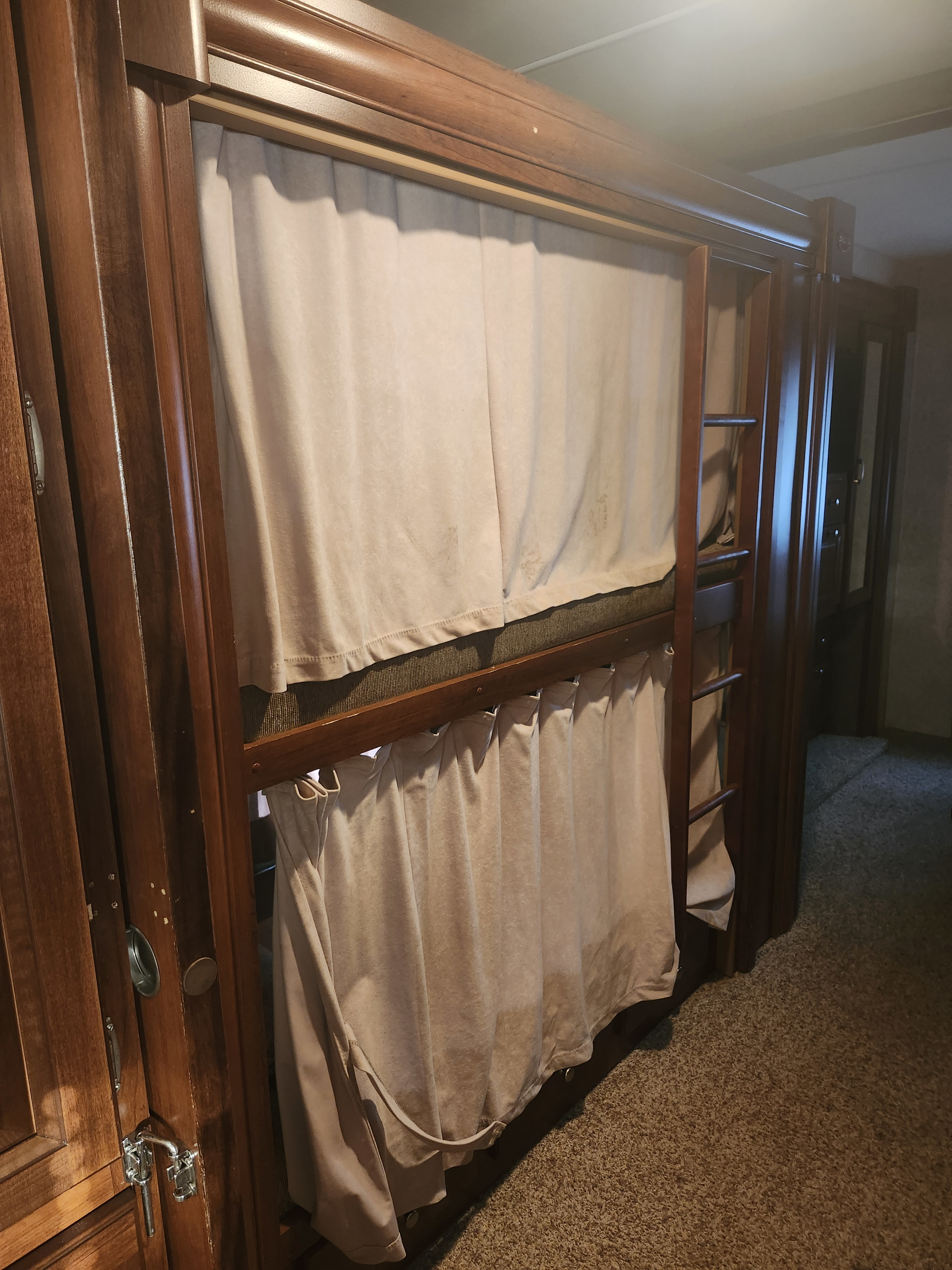 RV rental bunk beds with privacy curtains and a ladder, offering cozy sleeping space inside the camper.. Forest River Georgetown ts351 2013