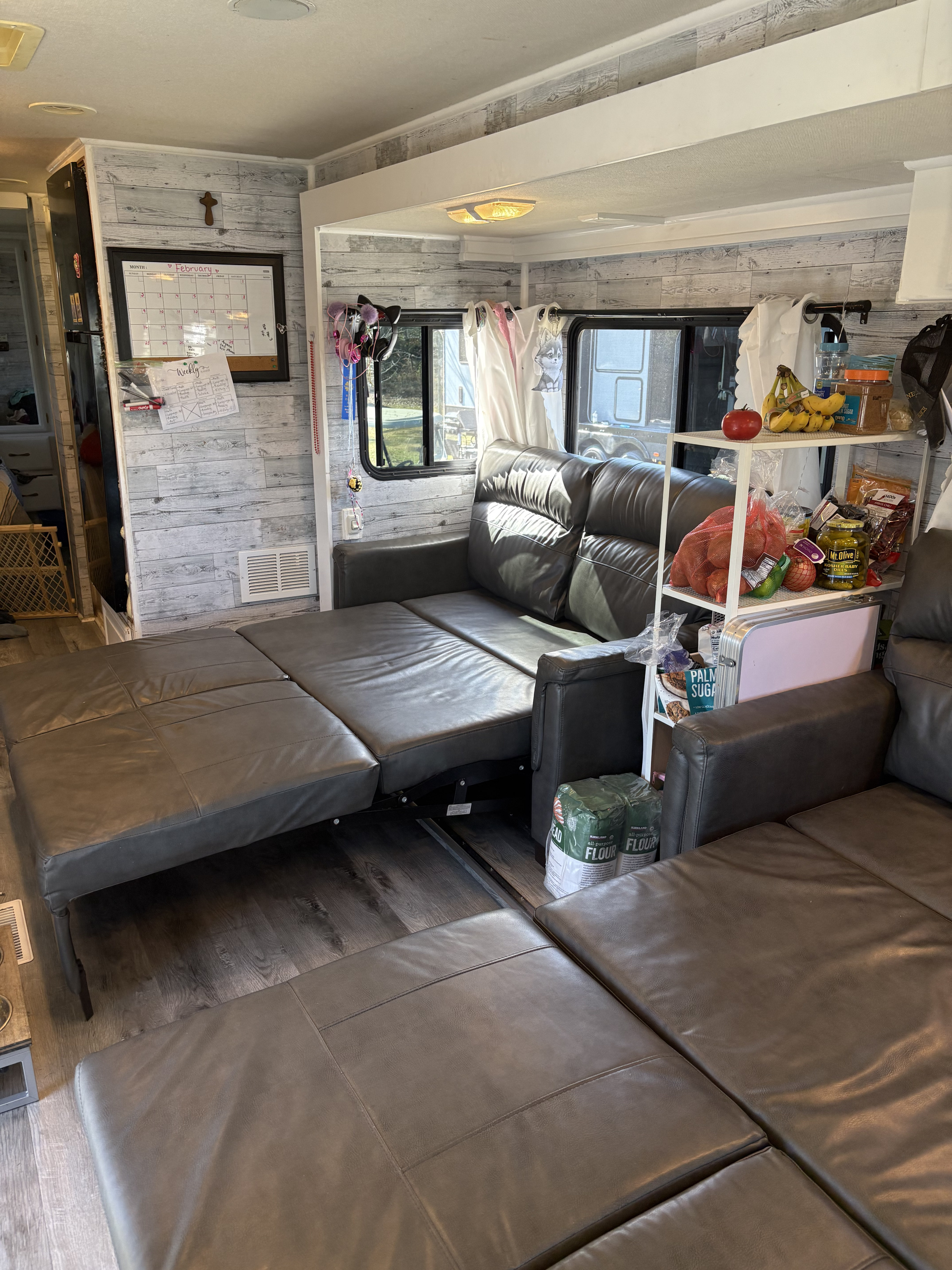 This RV rental features a versatile gray sleeper sofa, ideal for extra sleeping space in a cozy mobile home living area.. Georgie Boy Landau 2004