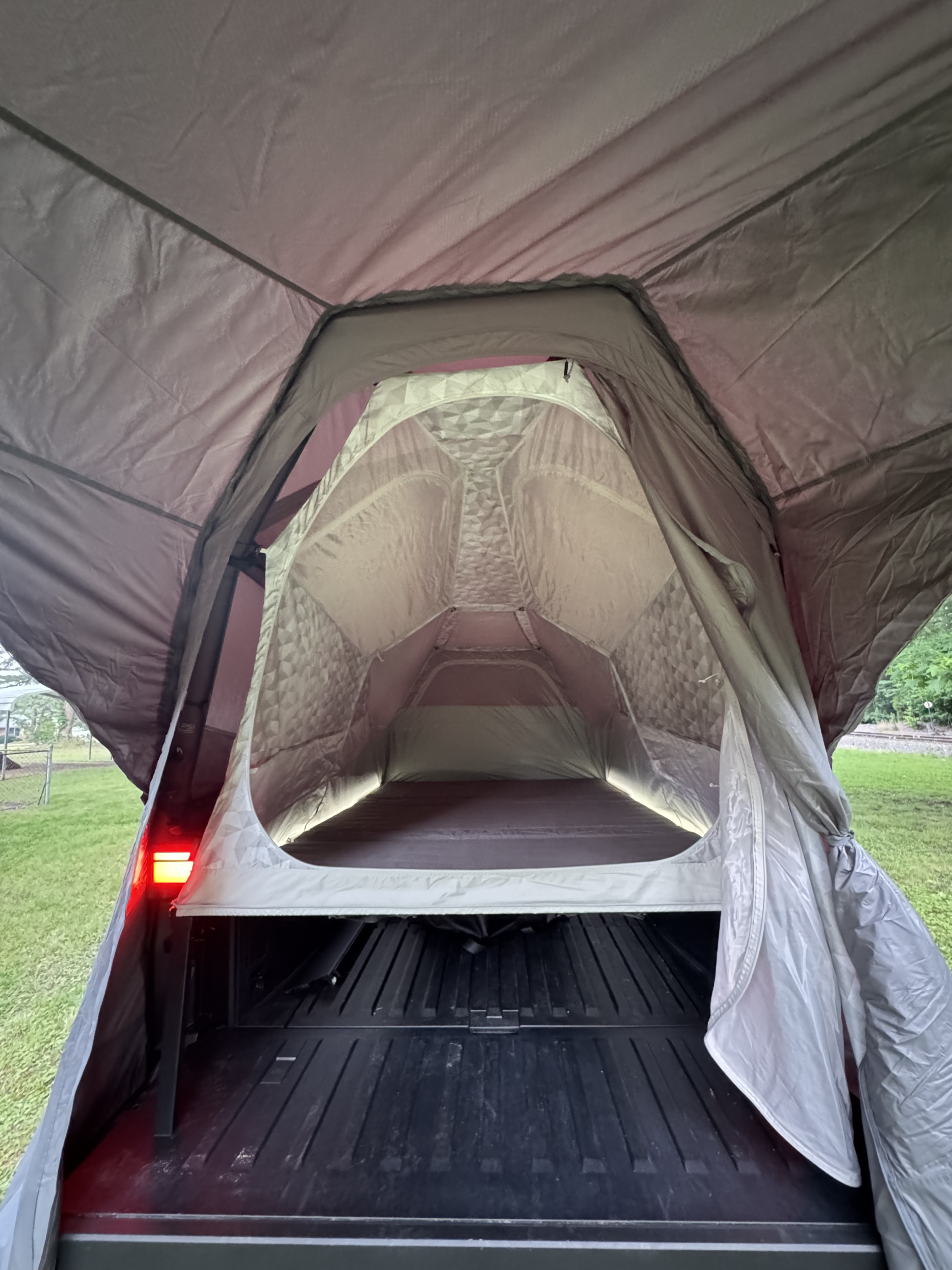 Inside a truck bed tent, offering a cozy sleeping setup for outdoor adventures. Perfect for an RV rental alternative.. Tesla Cybertruck 2025