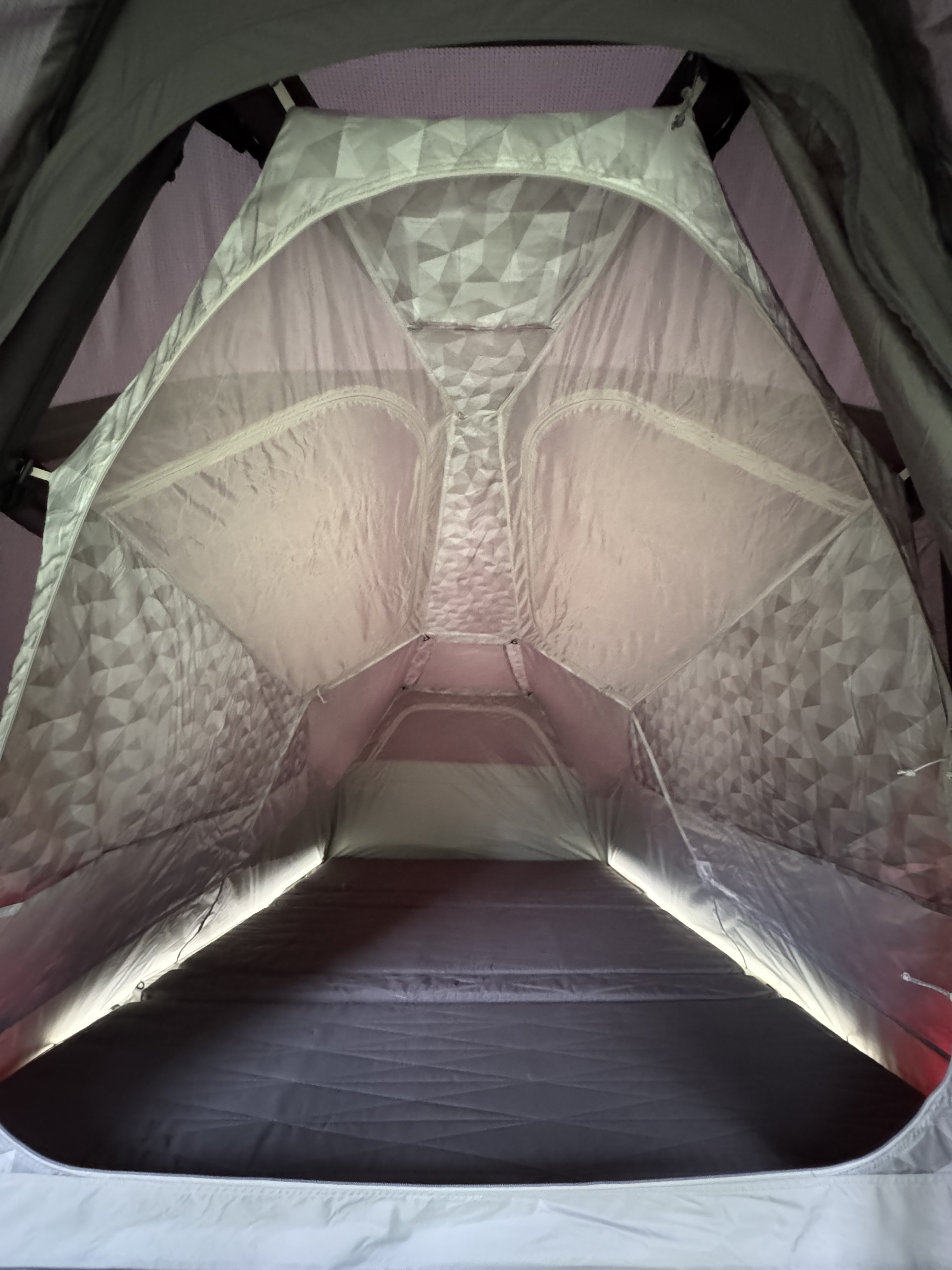 Cozy RV rental pop-up tent interior featuring patterned fabric walls, a plush mattress, and ambient LED lighting.. Tesla Cybertruck 2025