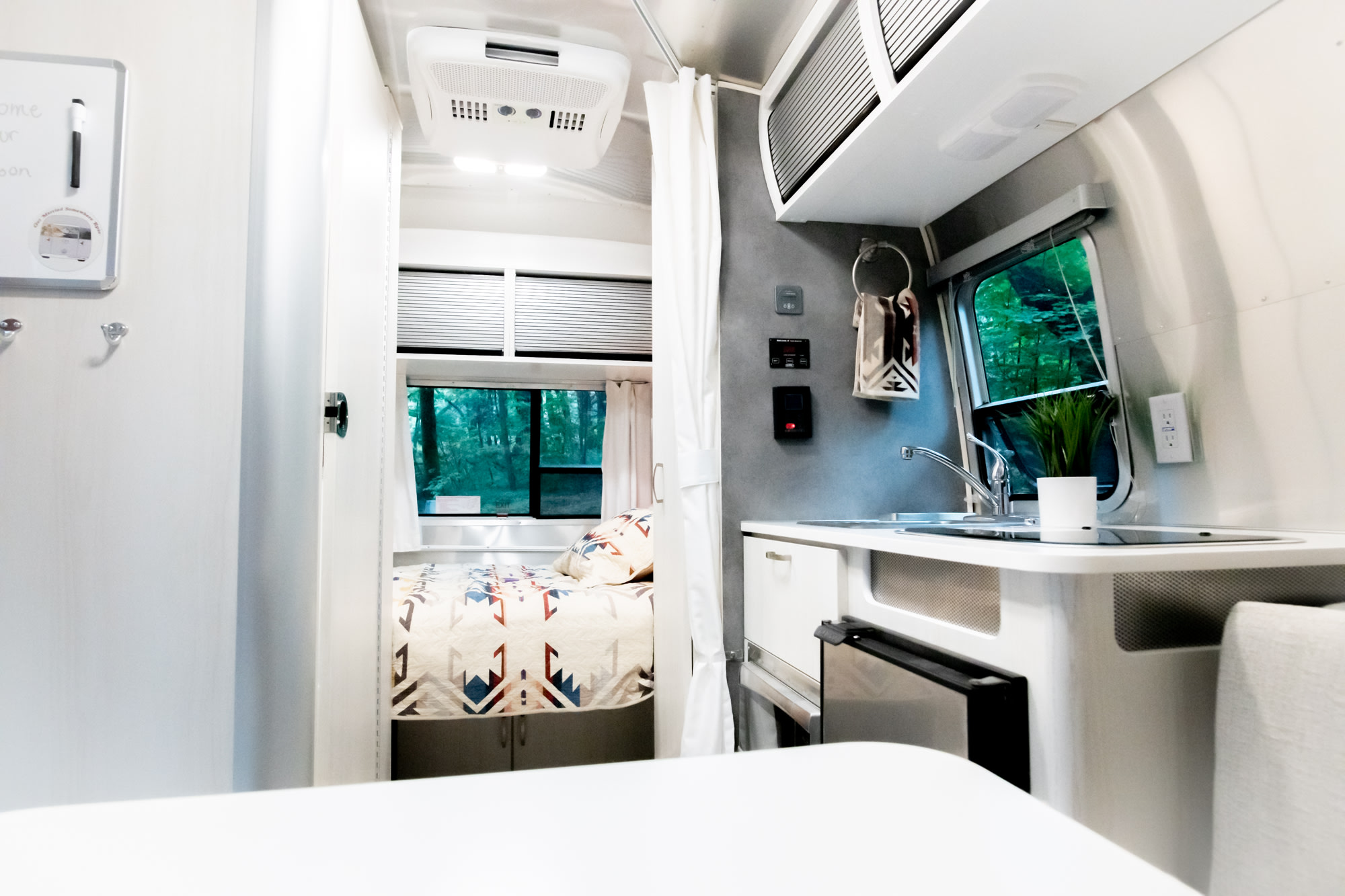 Cozy RV rental interior: modern kitchen, comfy bed, and nature views from the window, ideal for travel.. Airstream Bambi 2022