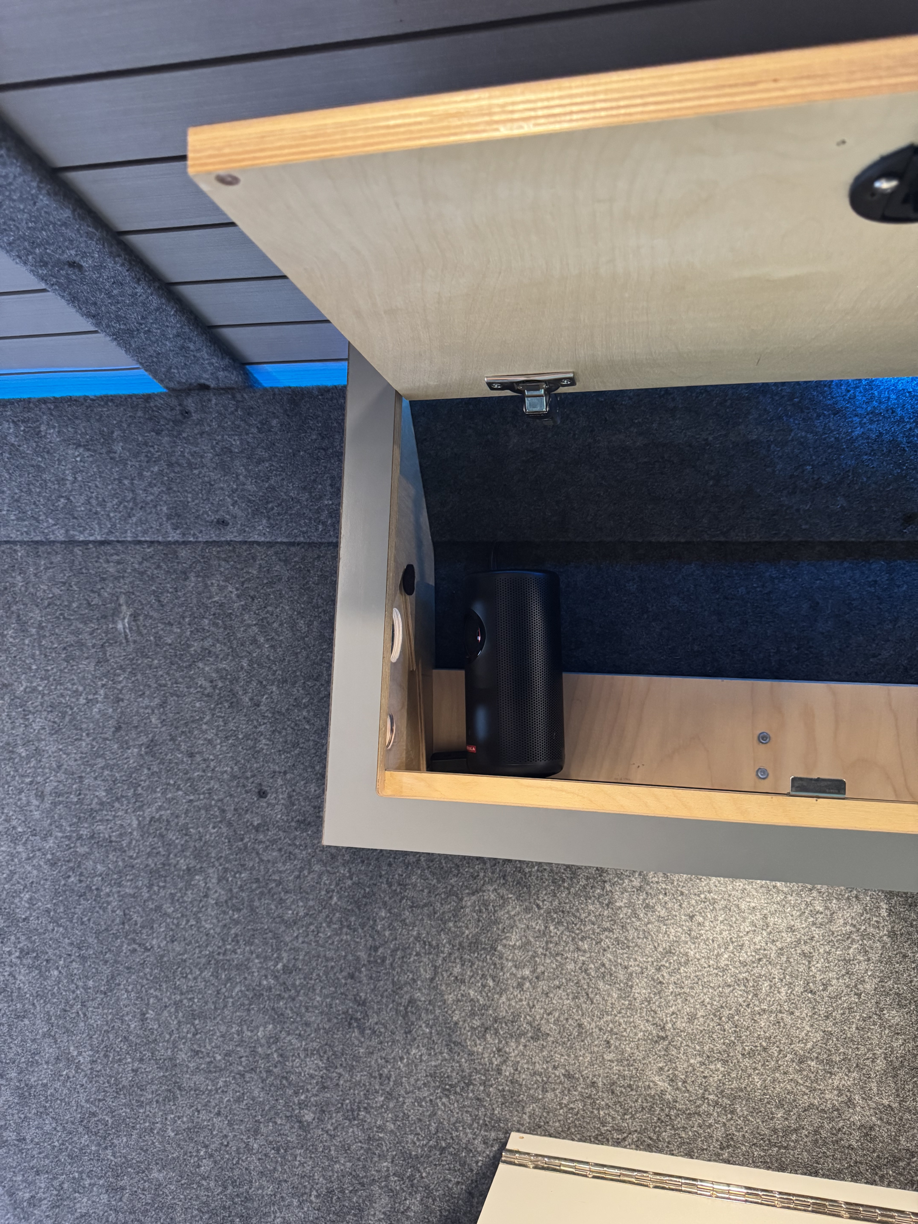 RV rental: Open overhead cabinet reveals a black projector, against felt-lined walls and a slatted ceiling.. Mercedes Sprinter 2021
