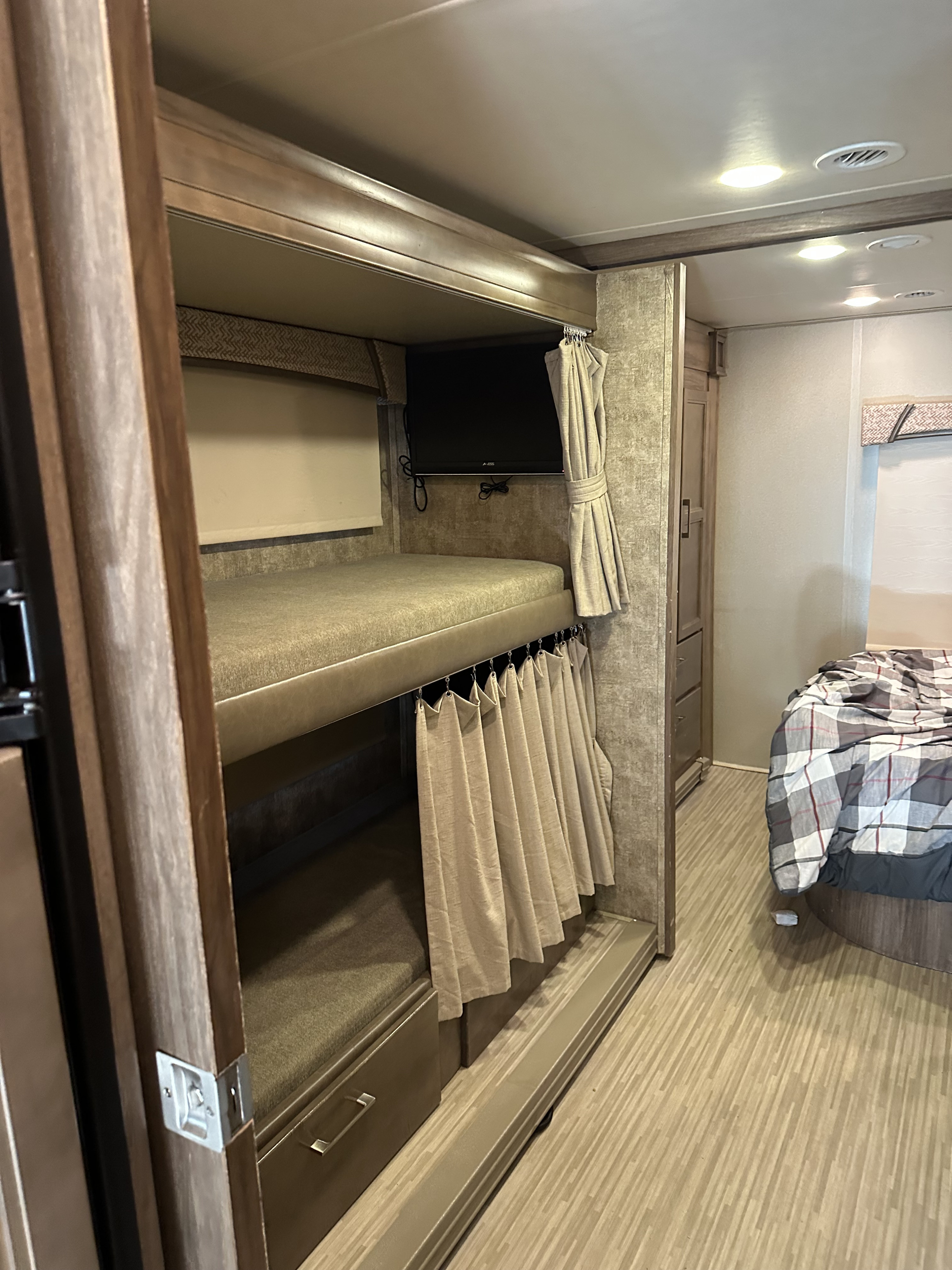 Inside this RV rental, discover comfortable bunk beds with a TV and a cozy private bedroom for travel comfort.. Jayco Greyhawk 2017
