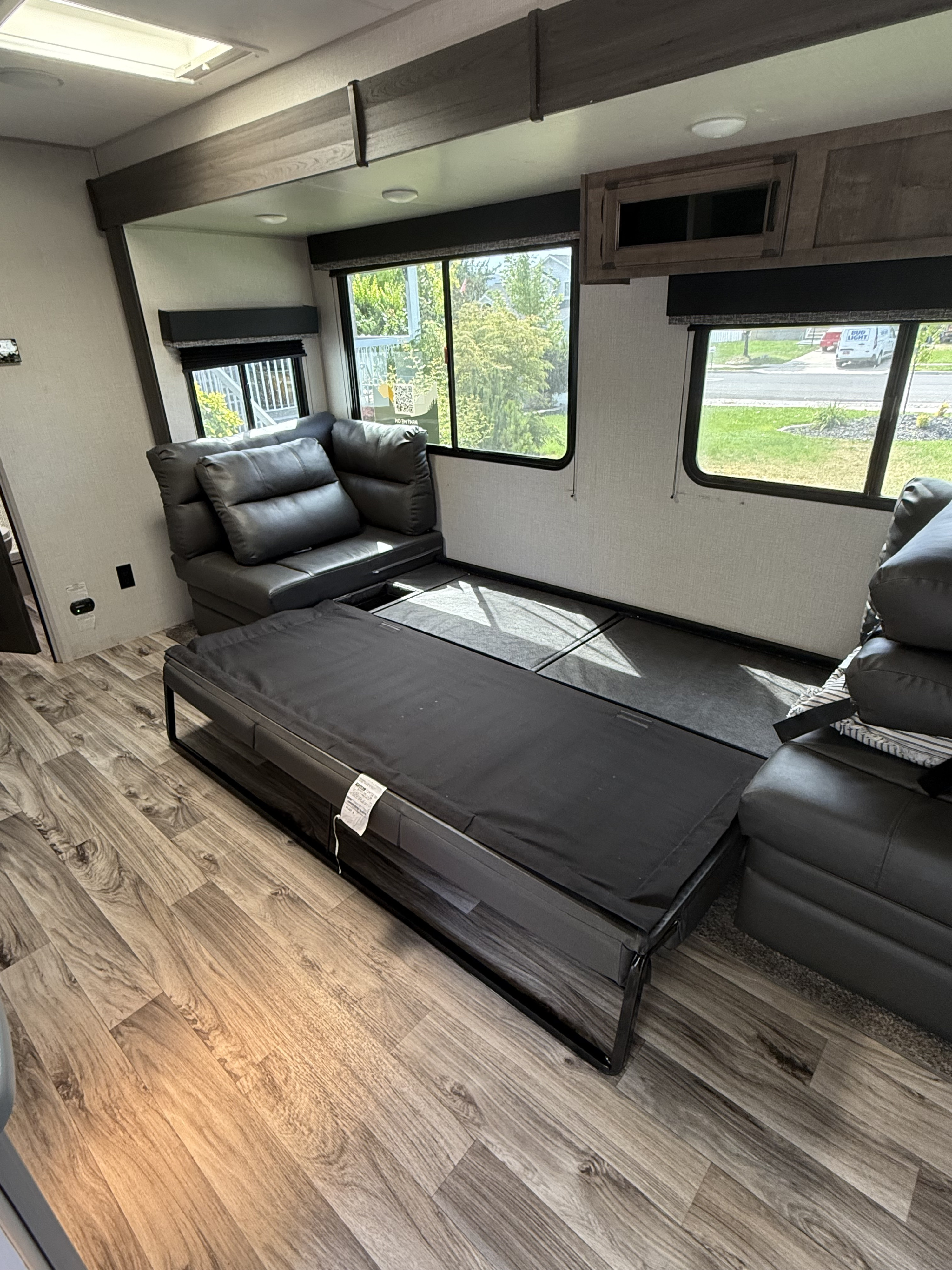 RV rental interior: Living space featuring a convertible sofa-bed, wood-look flooring, and bright windows.. Sport Trek 270 VBH 2021