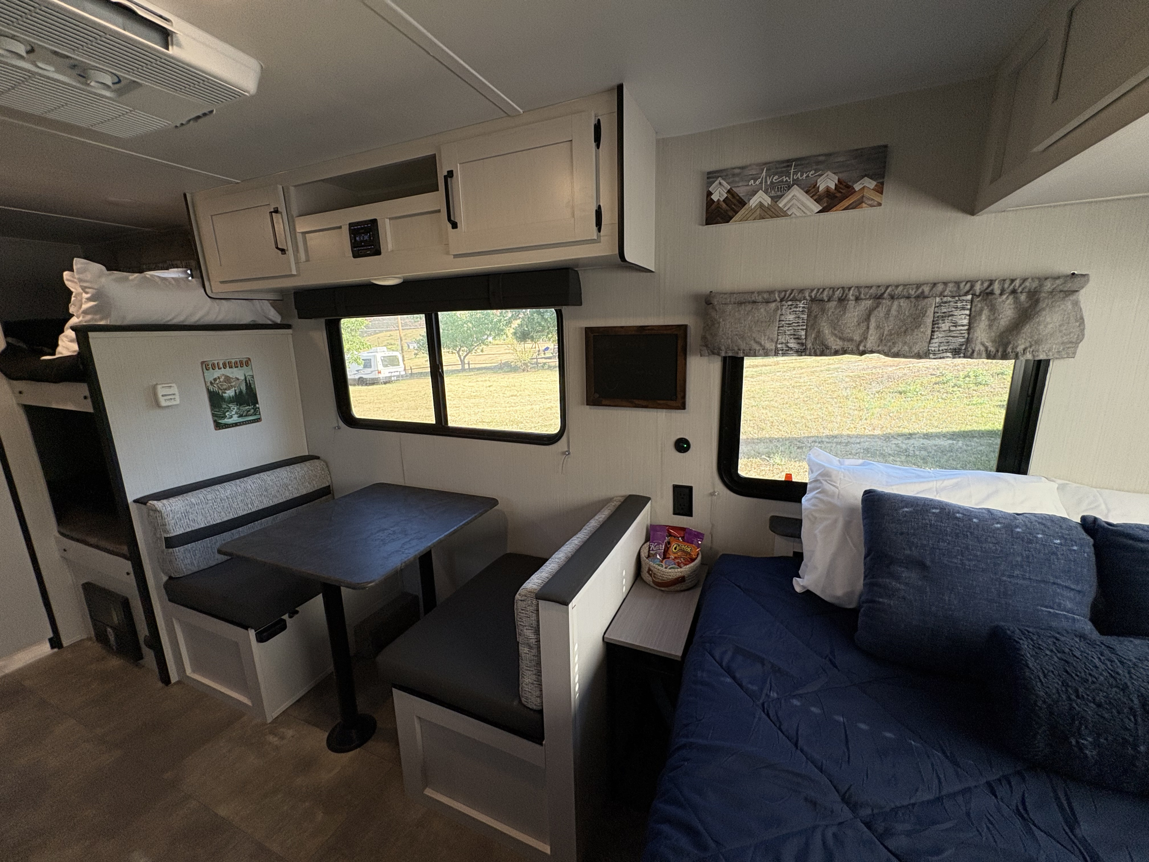 RV rental interior showcasing a full dinette, bunk beds, and a comfortable main bed. Ready for travel adventures.. Palomino Puma Ultralite 16BHX 2023