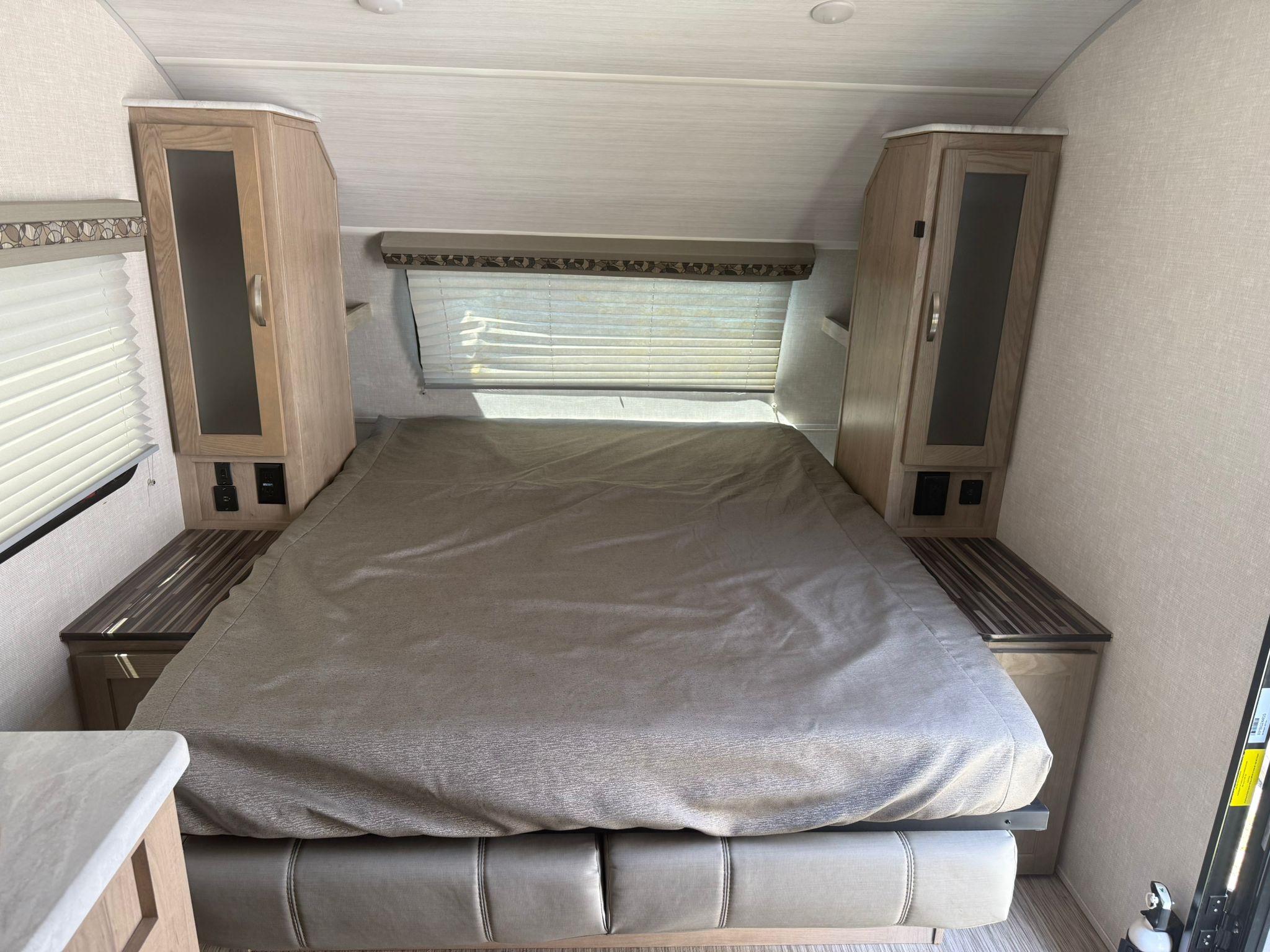 RV rental bedroom: a cozy interior with a bed, overhead storage, side tables with outlets, and a window at the head.. R-Pod R-Pod Trailer 2020