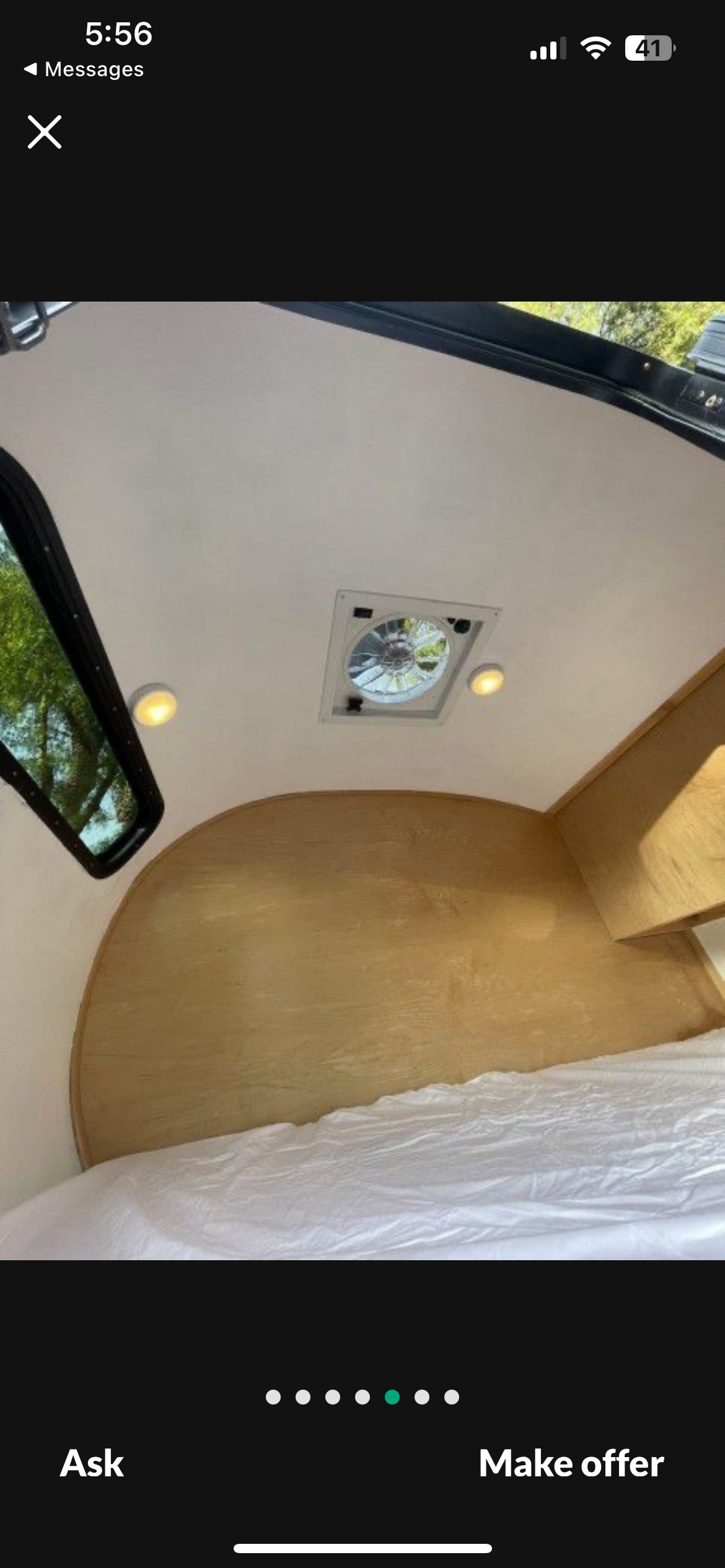 RV rental interior features: comfortable bed, arched wooden wall, window with outdoor views, ceiling fan, and lights.. Long Teardrop 2005