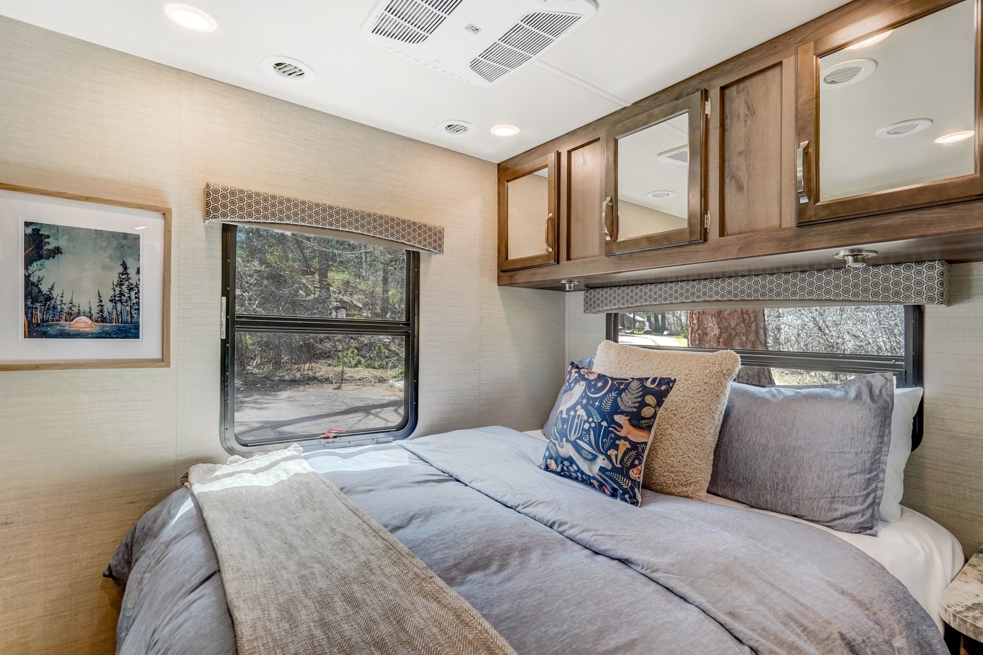 Cozy RV rental bedroom with comfortable bed, scenic windows, and overhead storage for a restful journey.. Jayco Greyhawk 2018