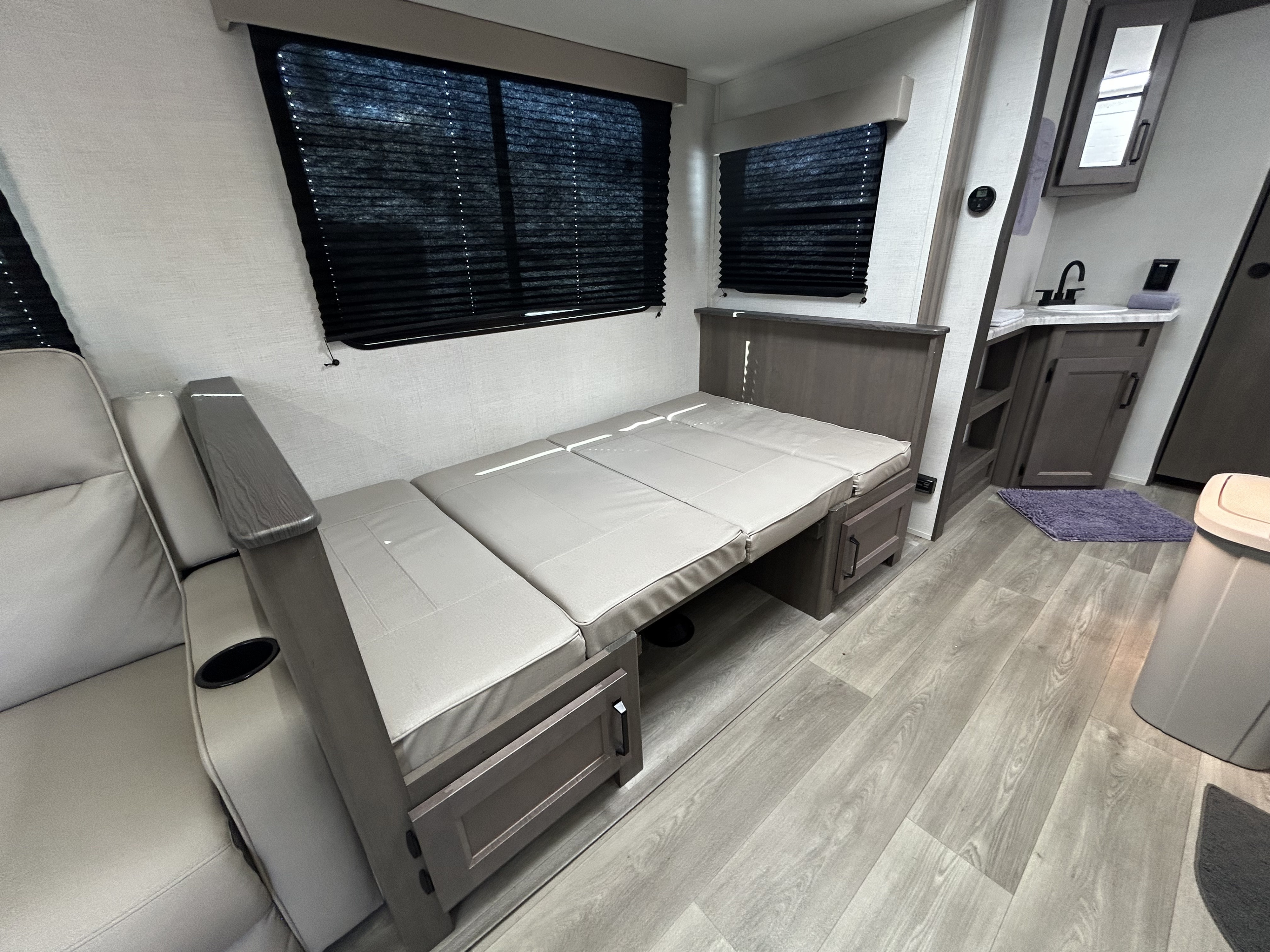 Spacious RV rental interior: convertible sofa/bed, kitchen/bath sink area, and comfortable seating.. Grand Design Transcend Xplor 2024