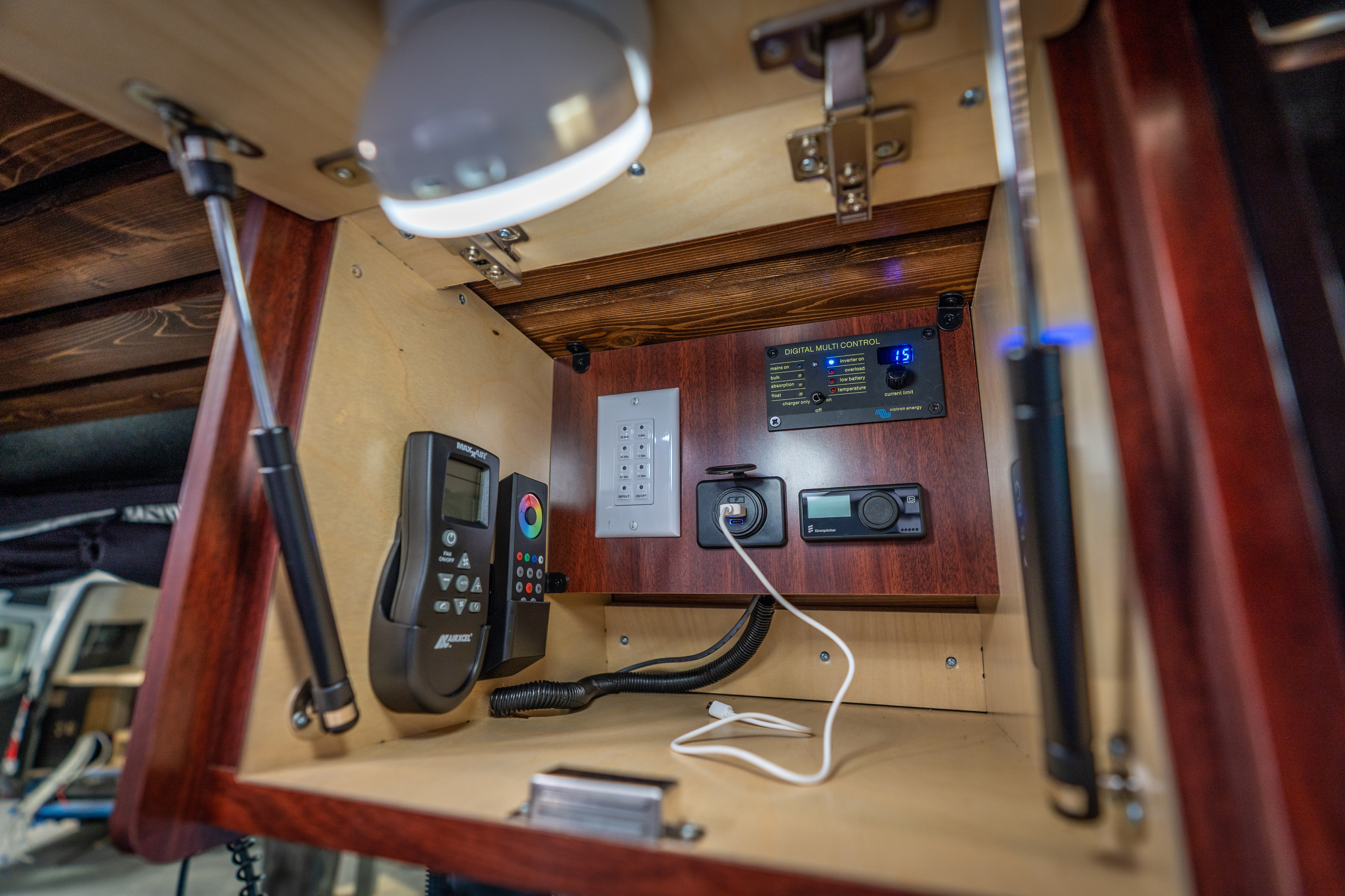 RV rental's organized interior control panel features Victron energy display, MaxxAir remote, Eberspächer, and USB charging.. Mercedes-Benz Sprinter 2025