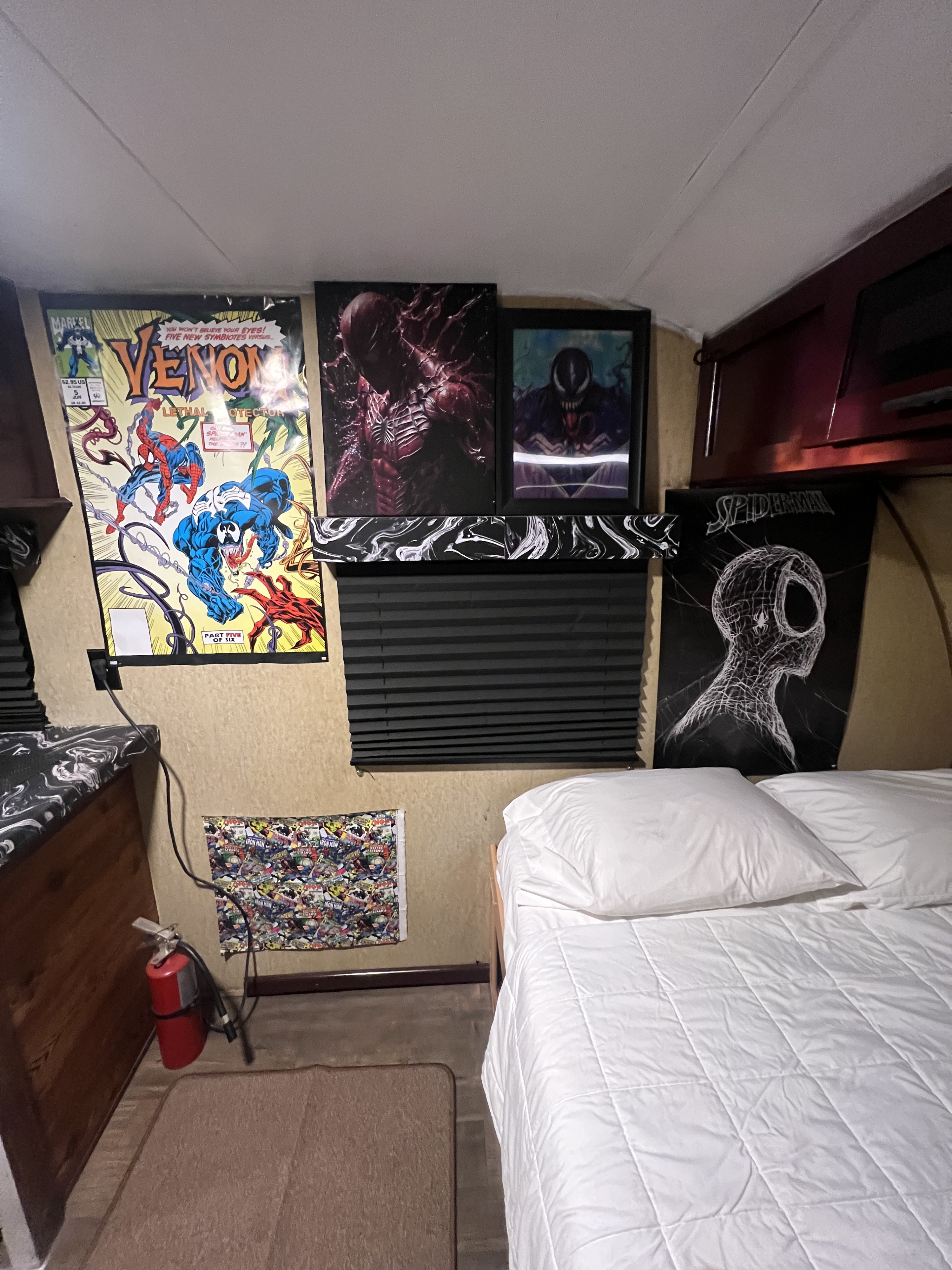 A comic book fan's dream RV rental bedroom, adorned with Venom & Spiderman art, a comfy bed & safety extinguisher.. Forest River Cherokee Wolf Pup 2016