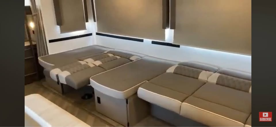 Modern RV rental interior featuring versatile L-shaped seating that converts to a bed, maximizing space for travel.. Forest River Salem 2022