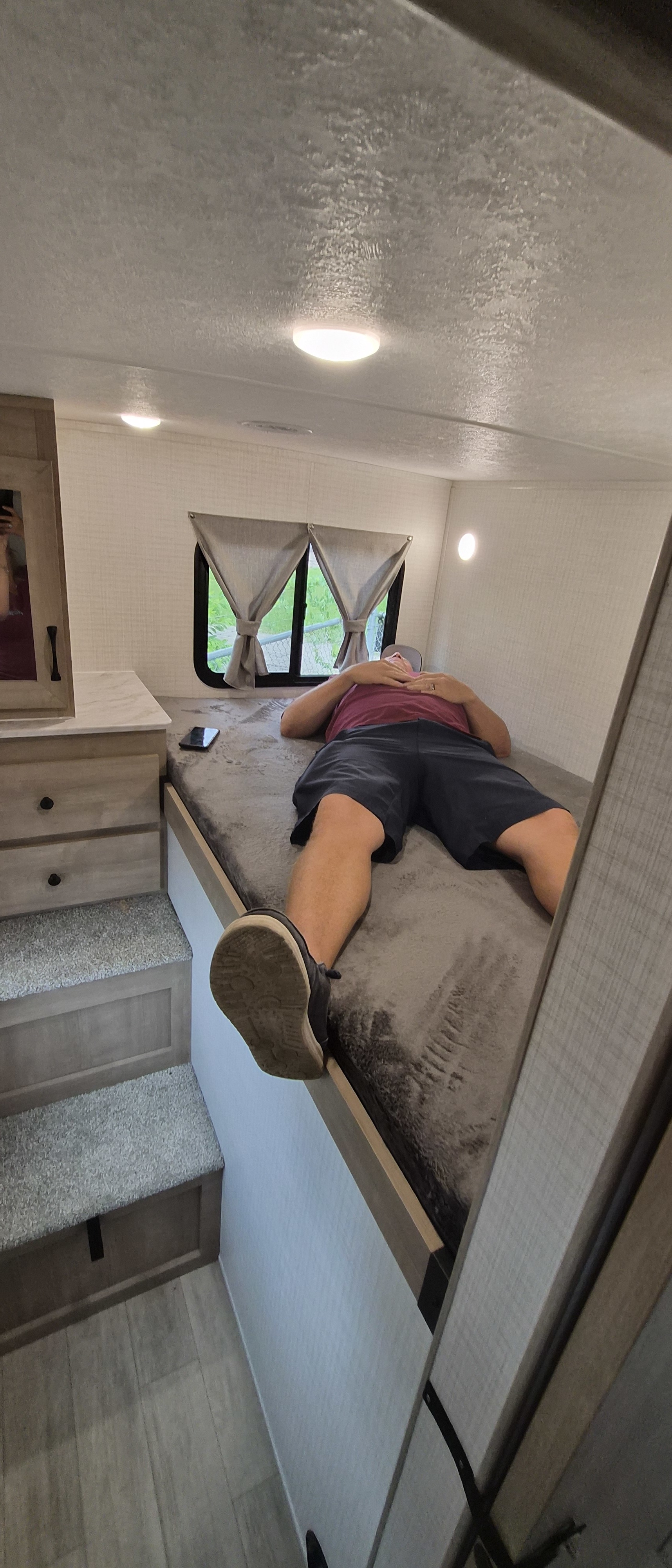 Relax comfortably in this RV rental! A person unwinds on a cozy bed inside a modern travel trailer.. Forest-river Solaire 3150 TBSS 2025