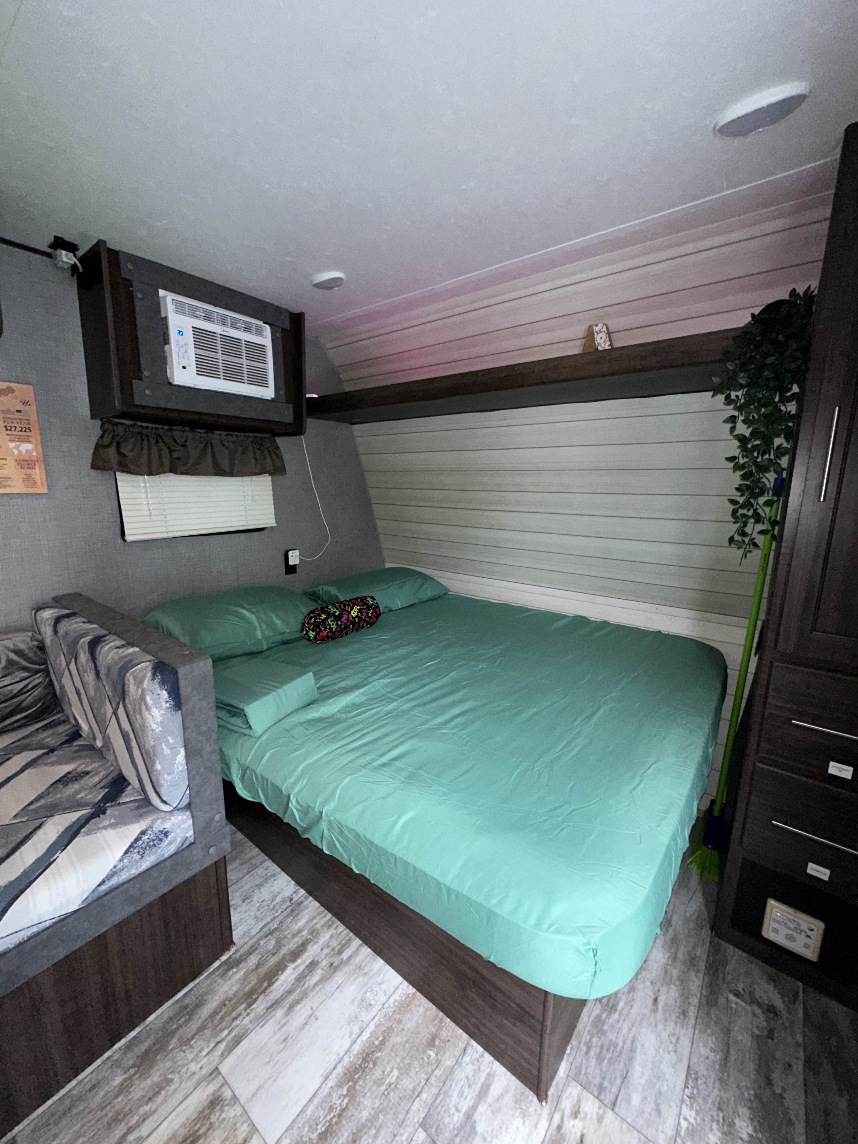 Cozy RV rental interior with a bed, sofa, and AC unit, perfect for a comfortable getaway.. Crossroads RV Z-1 Lite 2018