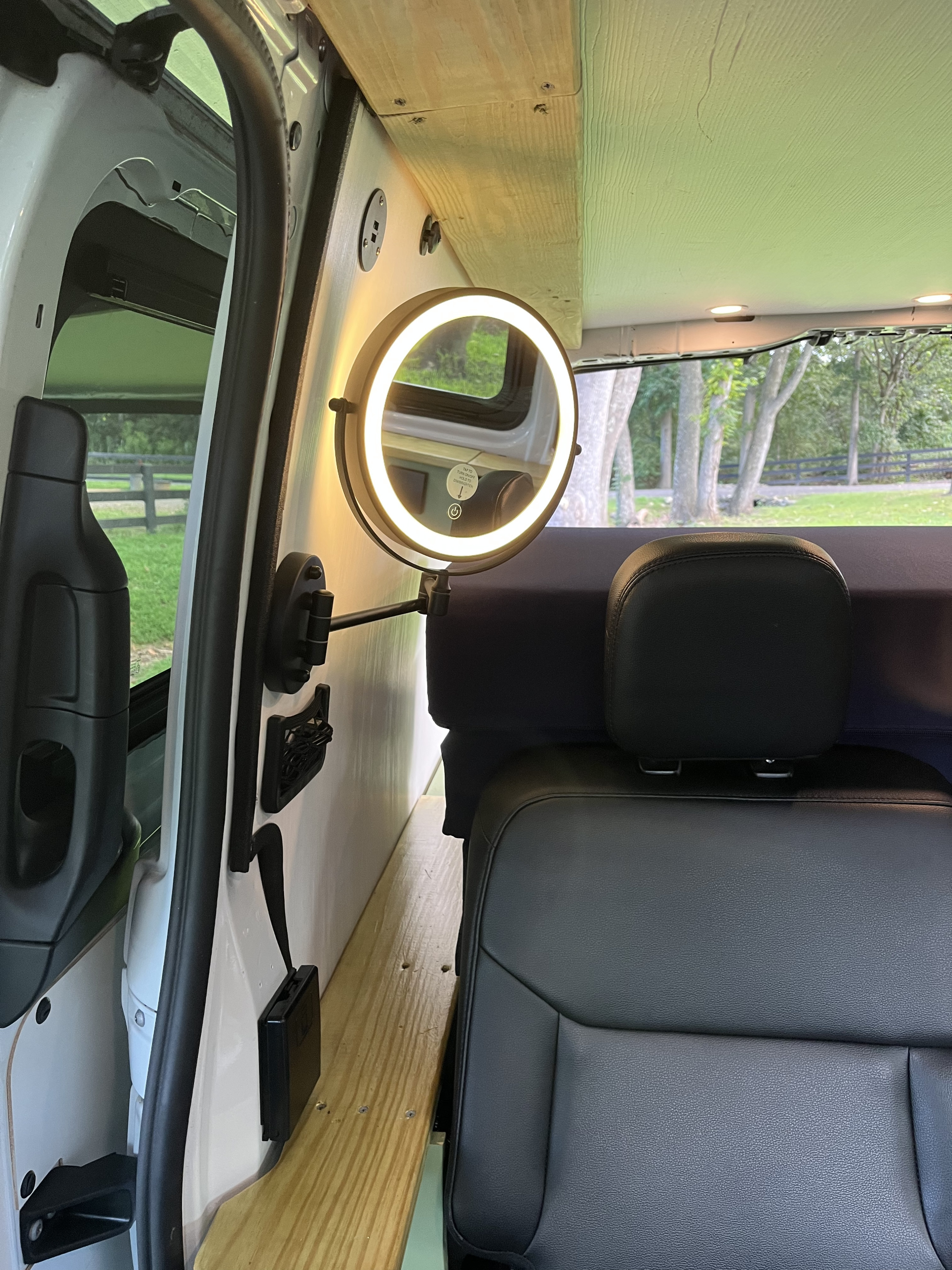 Cozy RV rental interior with a bed, swivel mirror, and wooden accents, perfect for van life adventures.. Homemade Mercedez Benz metris 2020