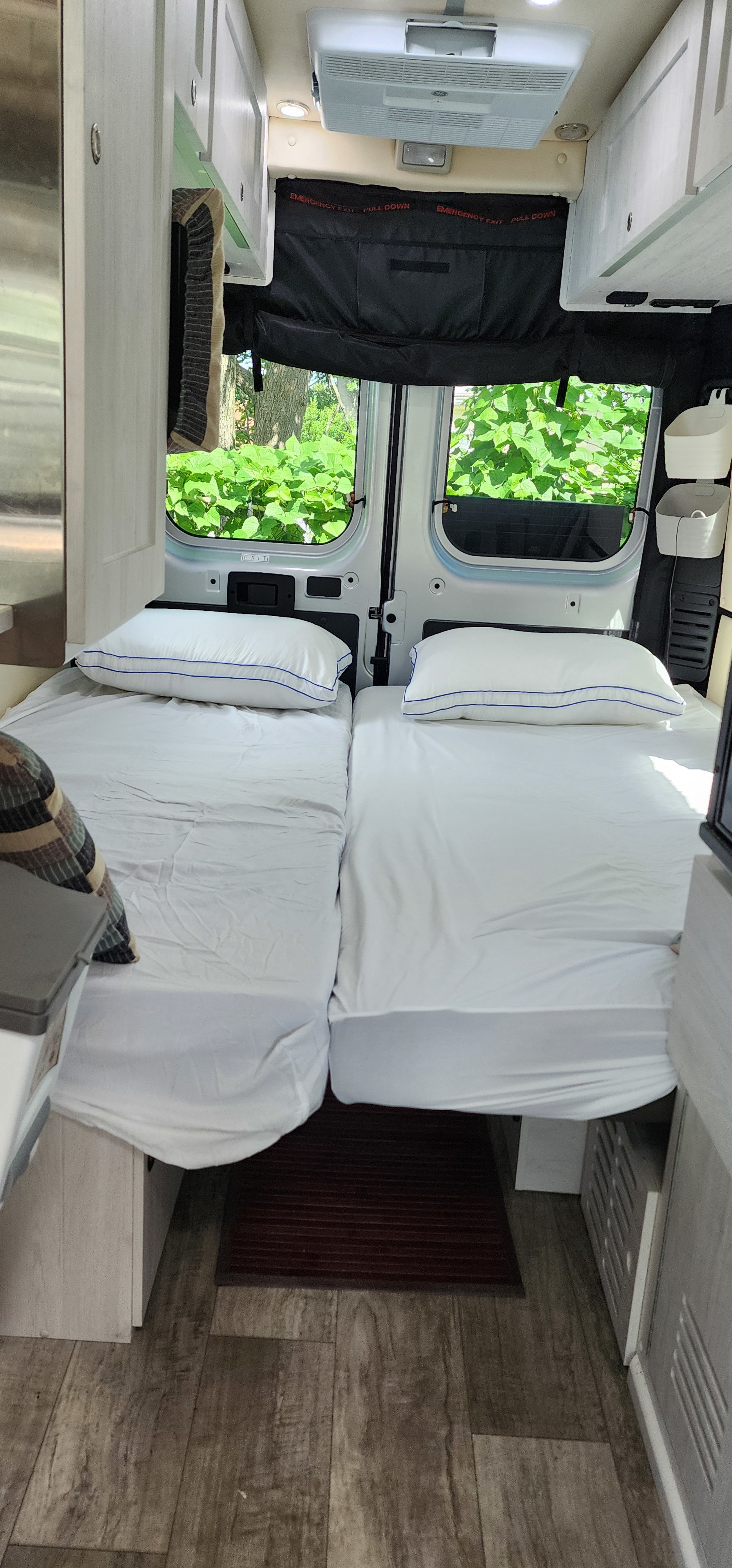 Cozy RV rental features twin beds, AC, and overhead storage, providing a comfortable space with refreshing nature views.. Roadtrek Roadtrek Class B 2023