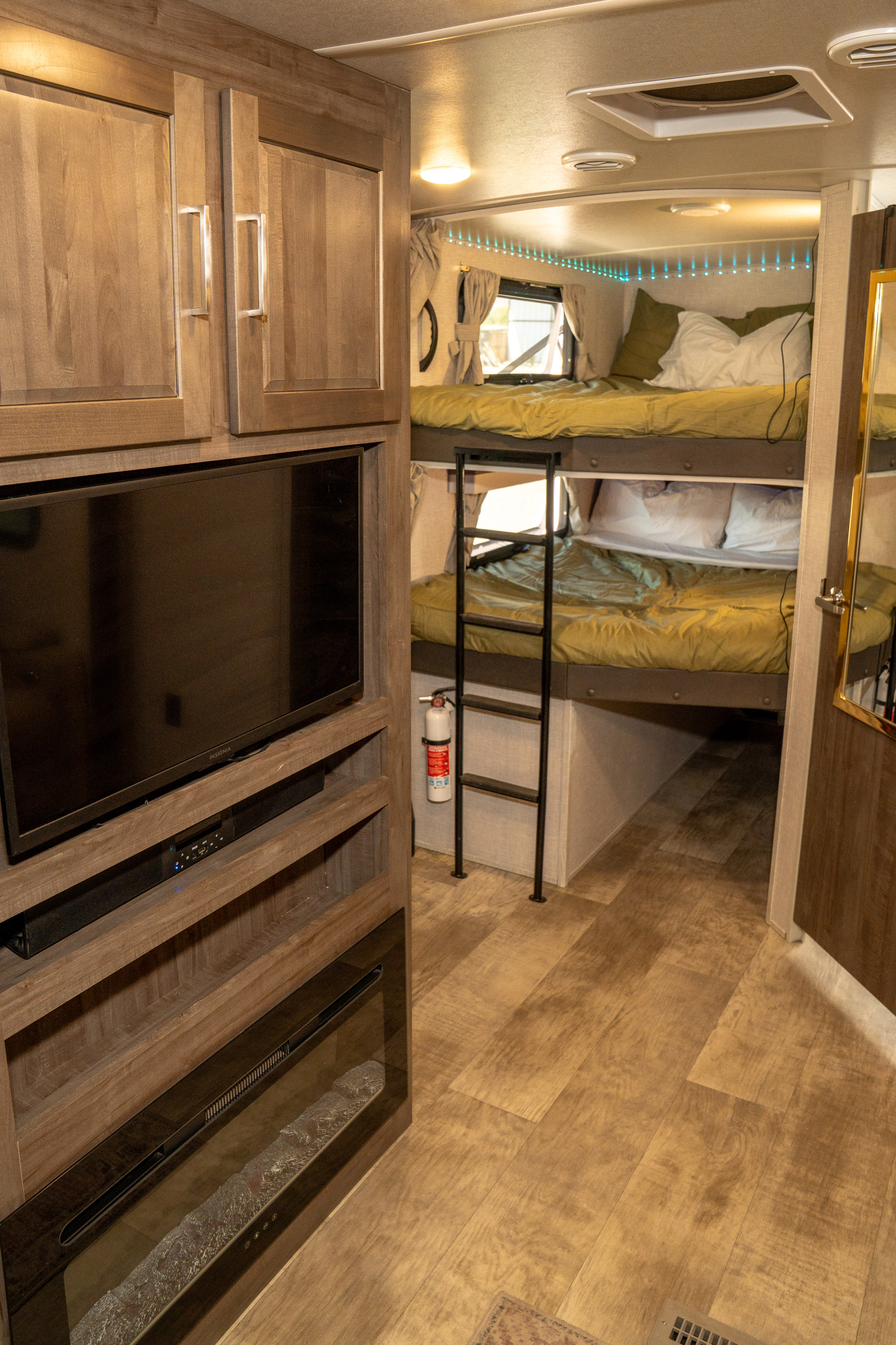 RV rental interior: Bunk beds, entertainment system with TV & fireplace, and ample storage create a cozy living space.. Forest River Rockwood Ultra Lite 2023