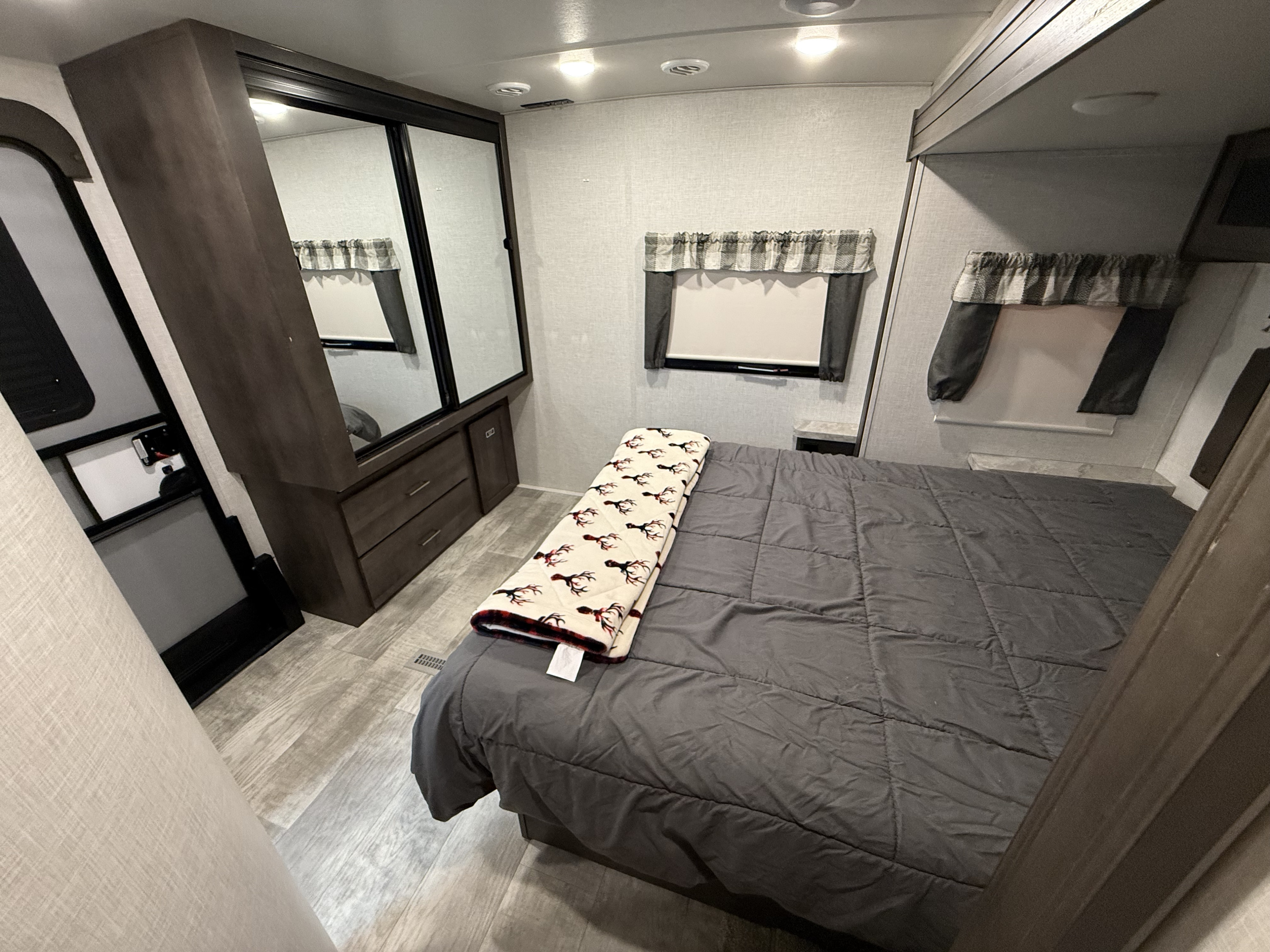 Cozy RV rental bedroom with mirrored closets, a comfy bed, and window treatments, perfect for travel.. Forest River Flagstaff Super Lite 2021
