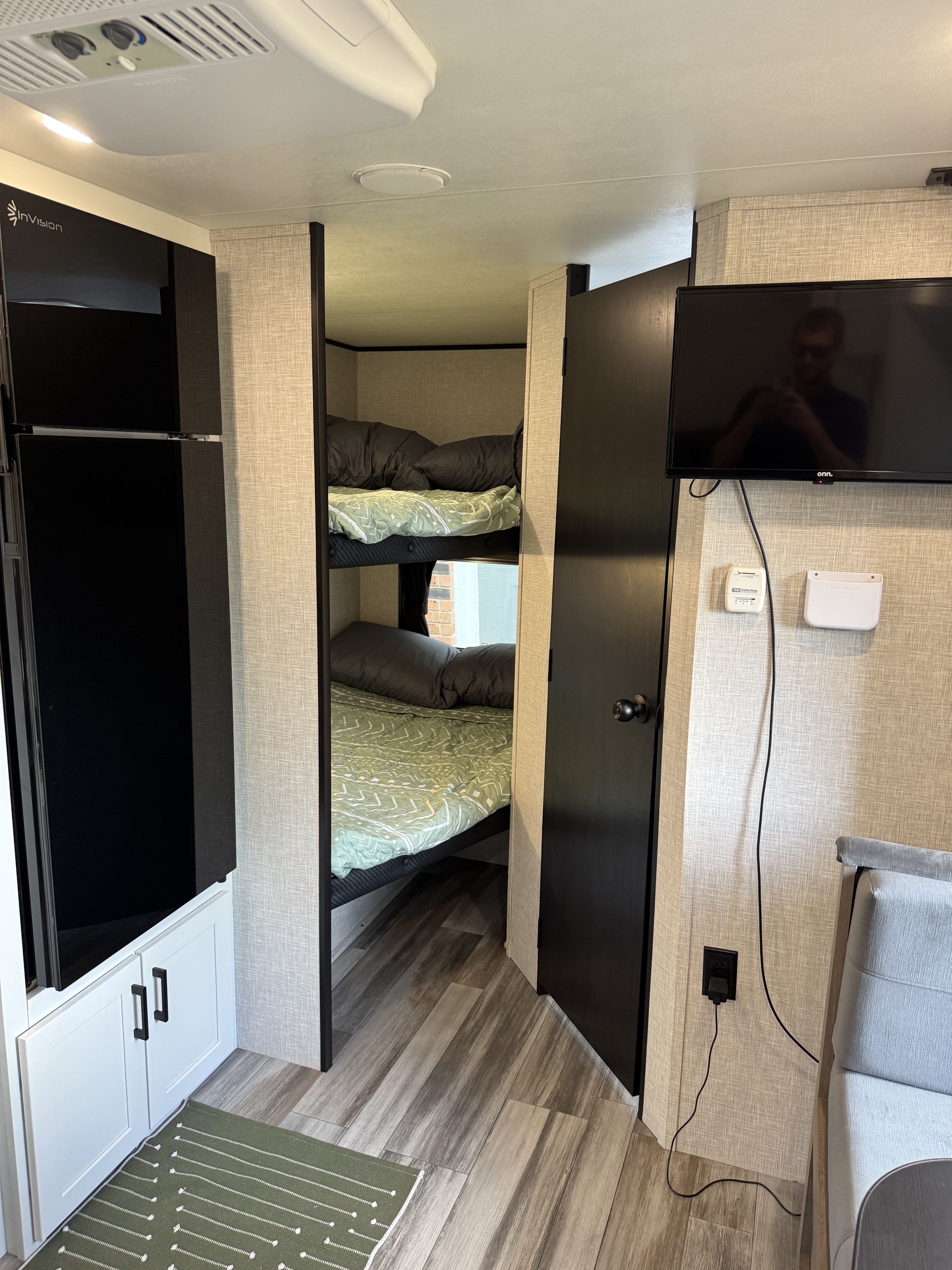 Cozy RV rental interior showcasing bunk beds, a mounted TV, and a tall refrigerator, ideal for family travel.. Jayco Jay Flight 197MB 2025