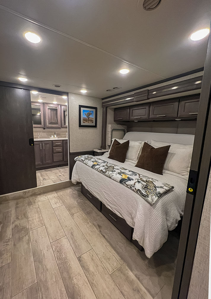 Spacious, modern RV bedroom with storage under the bed, overhead cabinets, and an adjoining bathroom. Ideal for your rv rental comfort.. Thor Motor Coach 2023