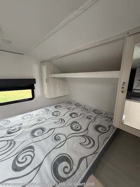 RV rental bedroom: Features a patterned mattress, overhead storage, and mirrored wardrobe for your next camper adventure.. Forest River Tracer LE 2021