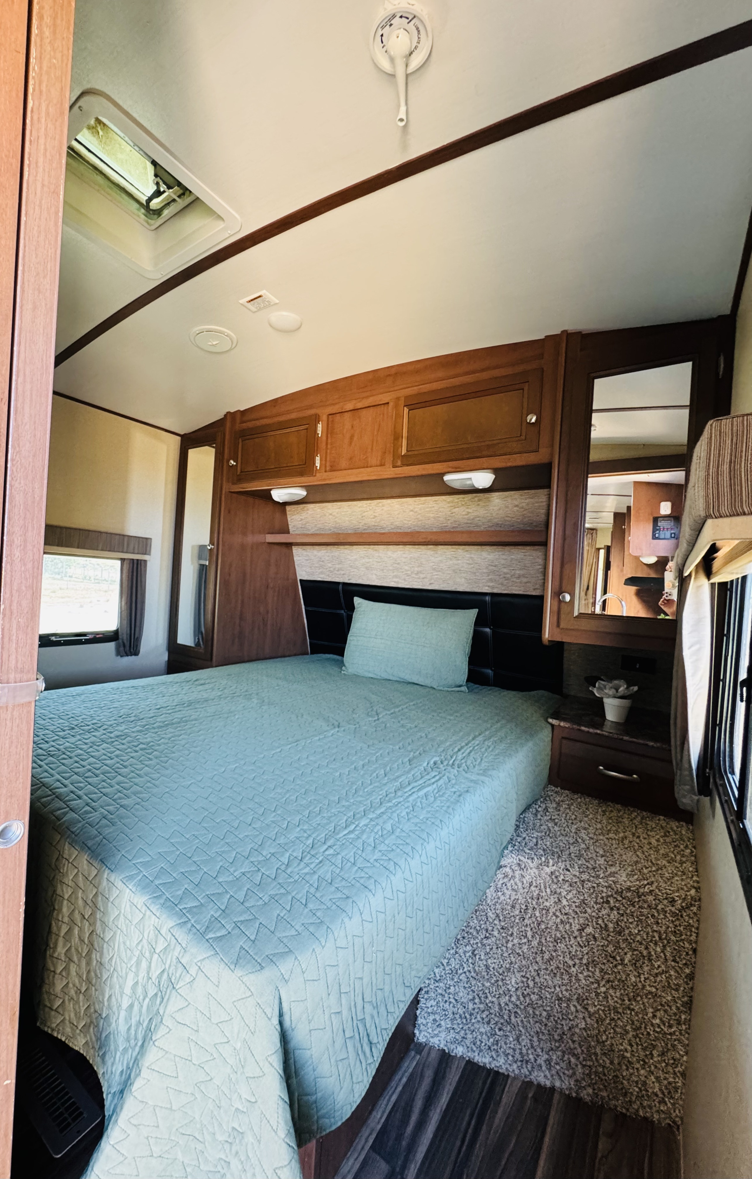 This cozy RV rental bedroom offers a comfortable bed, ample overhead storage, and a window for scenic views.. Dutchmen Denali Lite Series M-2611BH 2015