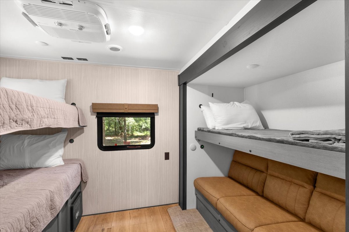 RV rental: Bright interior featuring multiple bunk beds, a cozy sofa, and a window showcasing nature.. Forest River Puma 2026