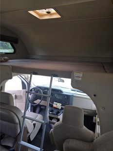 RV rental interior: Overhead bunk with ladder above the cab and front seats, ready for adventure.. Thor Freedom Elite 2020