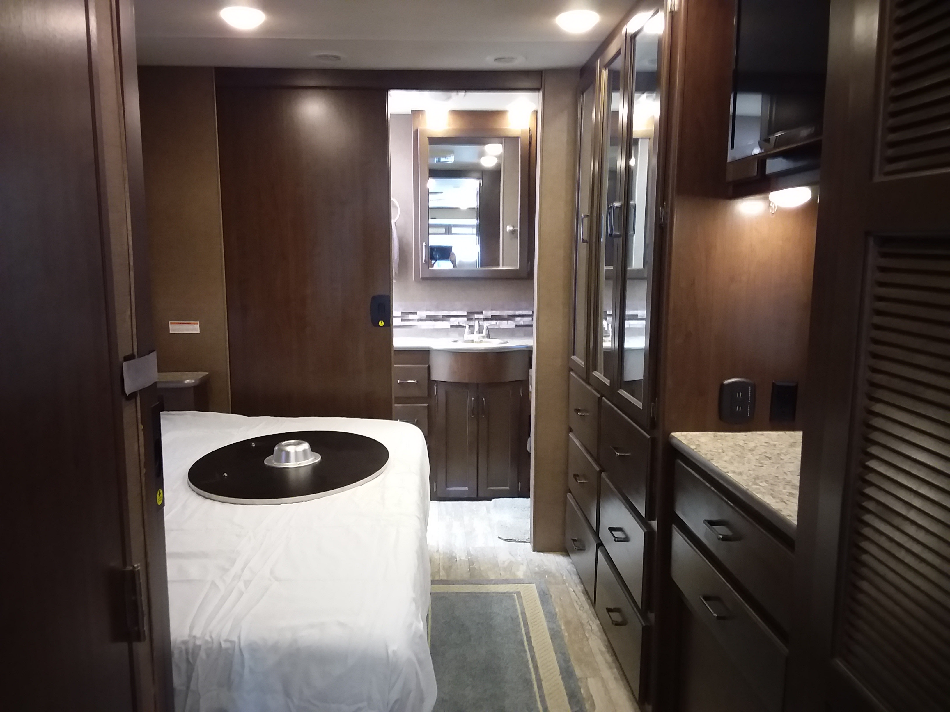 Explore this RV rental: master bedroom, ensuite bathroom with vanity & mirror, and abundant storage options.. Thor Hurricane 2019