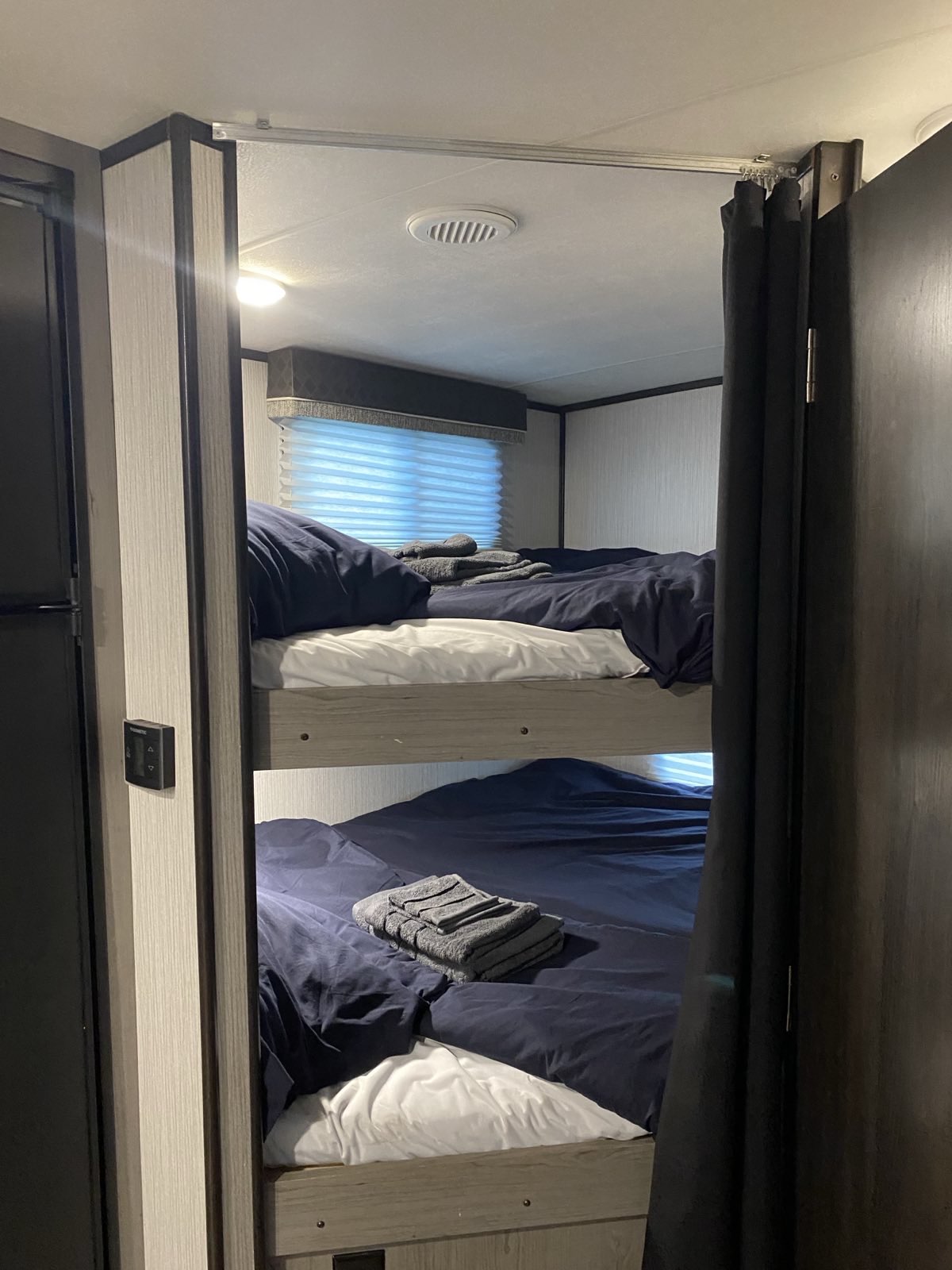 This RV rental offers comfortable bunk beds, complete with fresh linens and towels, plus a privacy curtain for guests.. Heartland RVs North Trail 2021