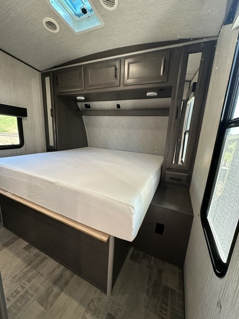 Bright RV rental bedroom showcasing a comfy bed, overhead storage, and windows for natural light. Ready for travel.. Heartland Fuel 287 2021