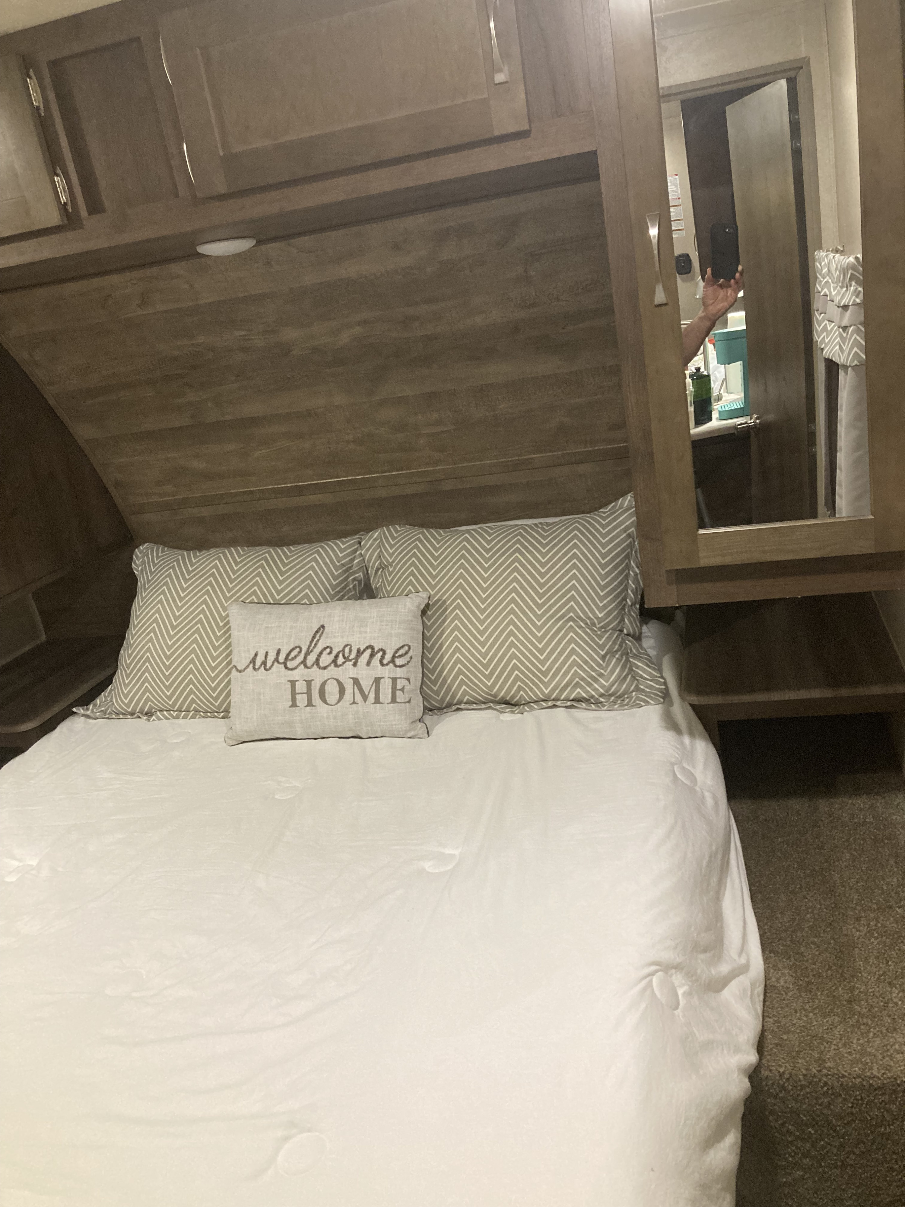 This RV rental bedroom offers a comfortable bed, overhead storage, and a mirrored cabinet door for convenience.. Palomino Puma 2020