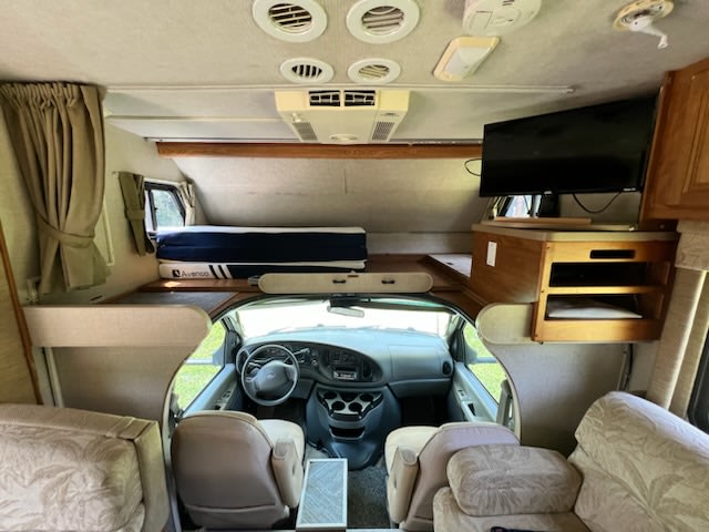 Step inside this spacious RV rental featuring an over-cab bunk, TV, and comfortable living area for your next adventure.. Tioga SL 2006