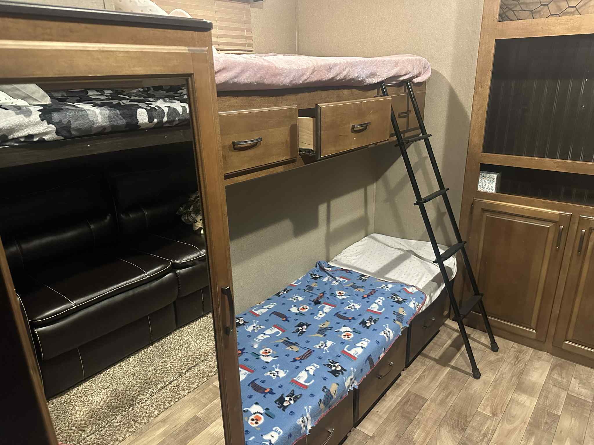 RV rental: Bunk beds with storage drawers, a ladder for the upper bunk, and a visible sofa, showing a compact living space.. Grand Design Reflection 2017