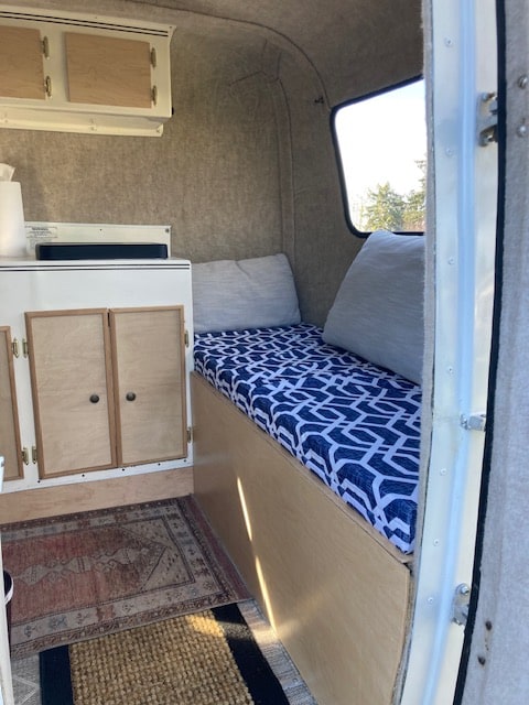 Cozy camper interior for your next RV rental adventure. Features bench seating, cabinets, and a window. Perfect for travel!. Scamp Scamp Trailer 1988