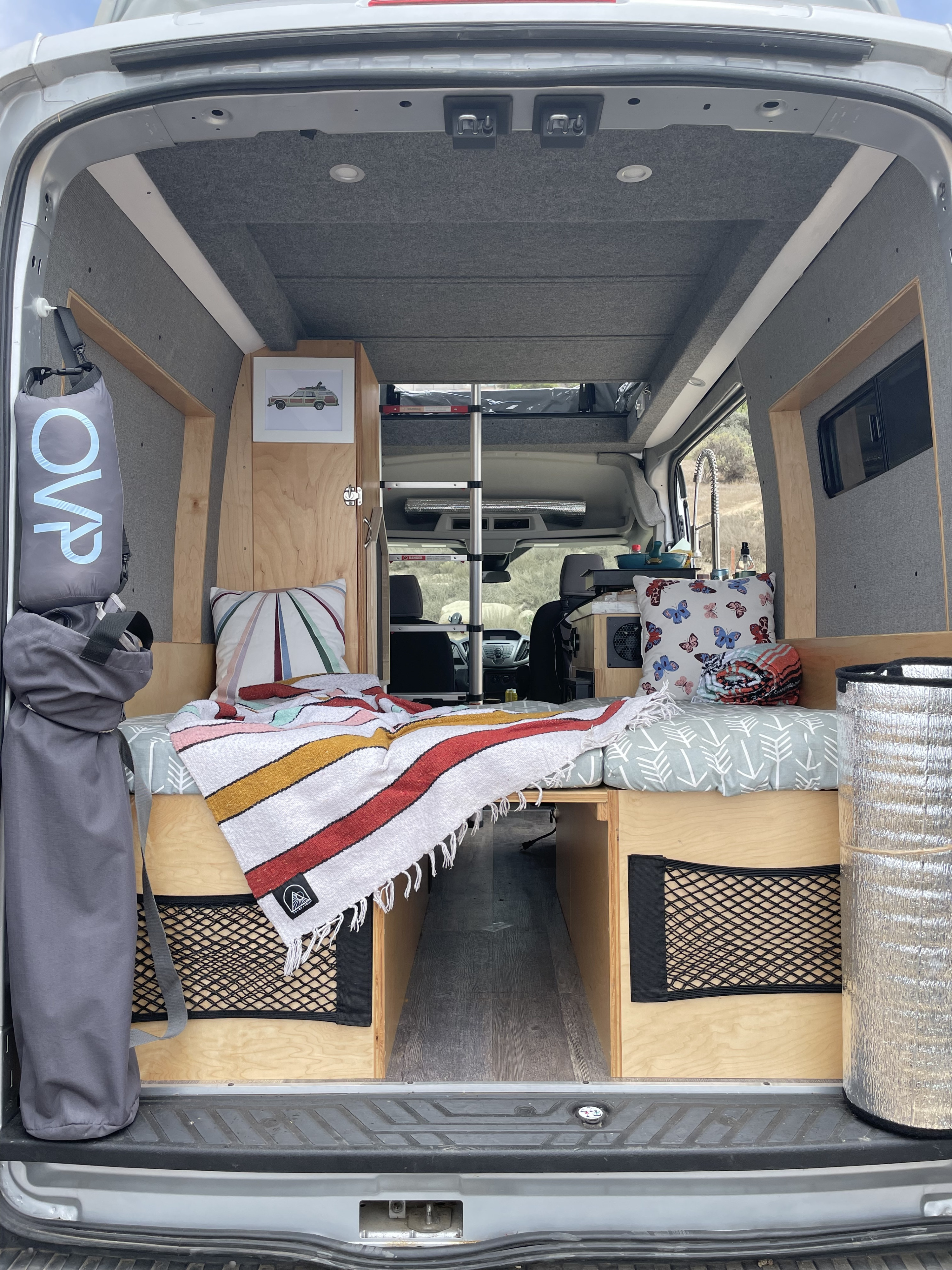 Cozy camper van interior: bed, storage, & kitchen area, ready for an RV rental adventure.. Ford Custom Transit 2016