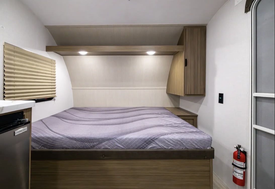 Cozy RV rental bedroom with modern design, built-in storage, mini-fridge, and essential fire extinguisher.. Forest River Salem 2026