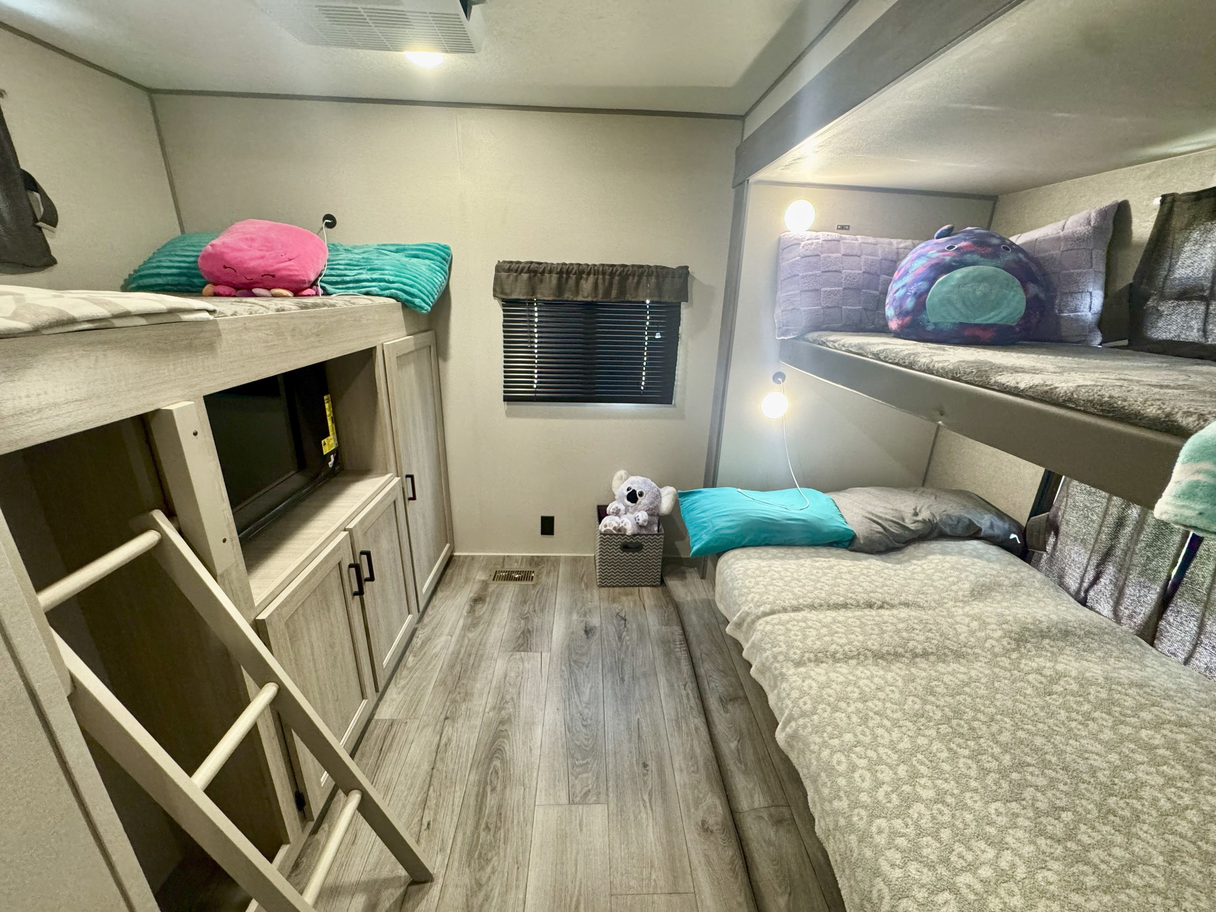 This RV rental features a compact bunk room with multiple beds, built-in storage, and reading lights, ideal for families.. Forest River Coachmen Catalina Legacy 2024