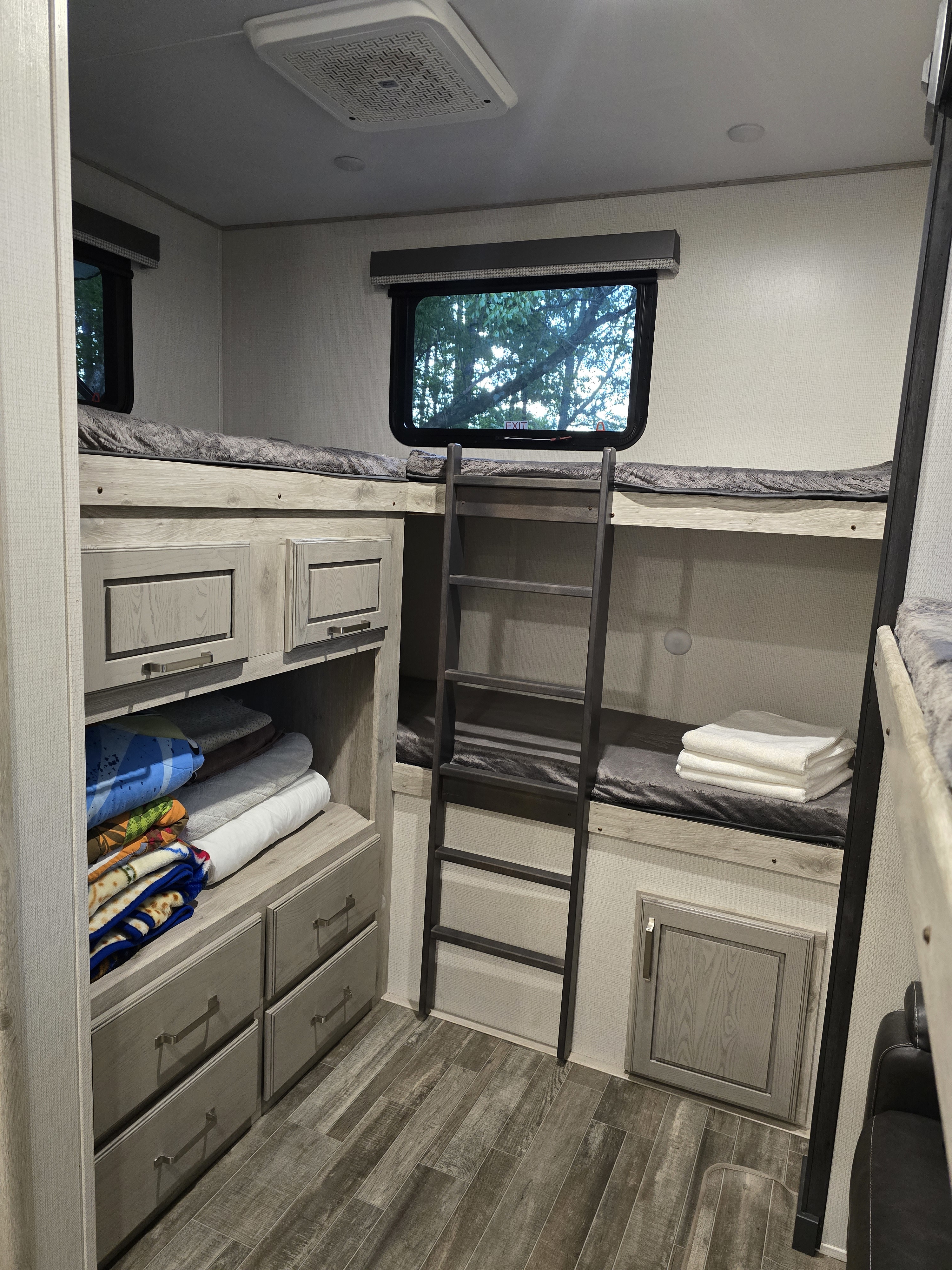 Spacious RV rental bunkhouse featuring multiple bunks, ample storage, and comfortable bedding. Perfect for family travel.. Keystone RV Avalanche 2023