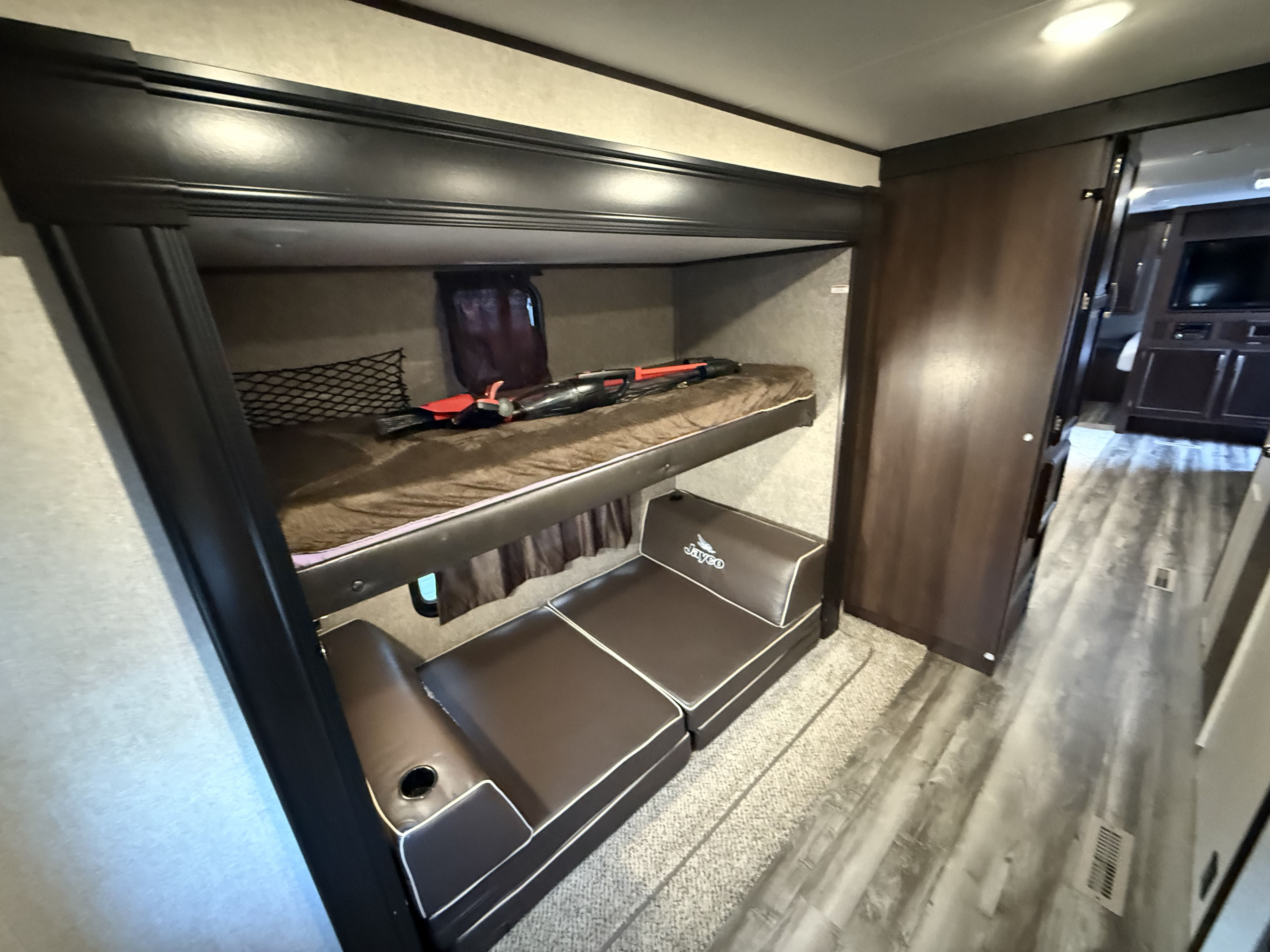 Cozy Jayco RV rental bunkhouse with bunk beds, convertible seating, and a cup holder in a travel trailer interior.. Jayco Jay Flight 2020