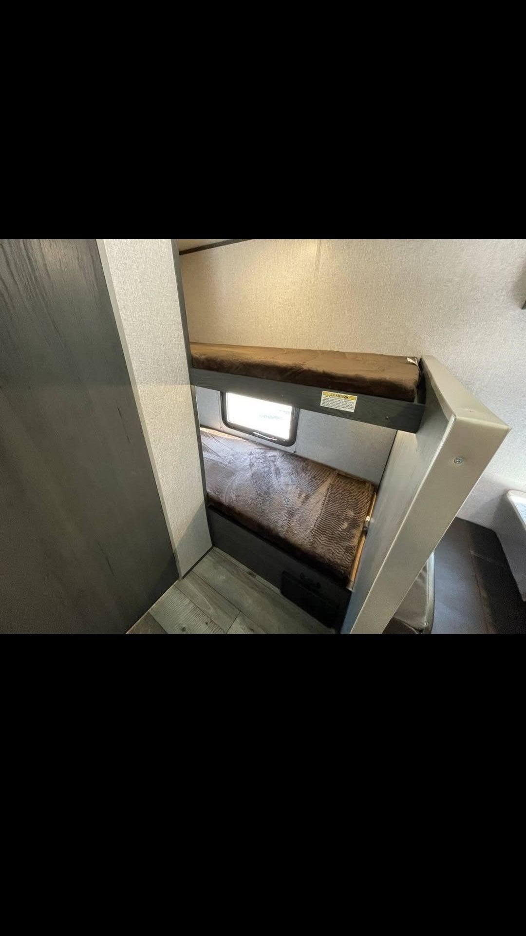 Cozy RV rental sleeping area with two bunk beds and a window, ideal for compact travel adventures.. Aspen Trail AT17BH21 2021