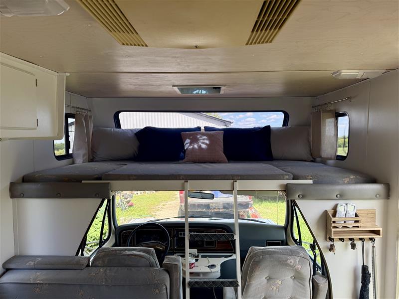 Inside this RV rental: view of the cozy cabover bed, front cabin, and driver's area for your adventure.. Ford Econoline Club Wagon 1988