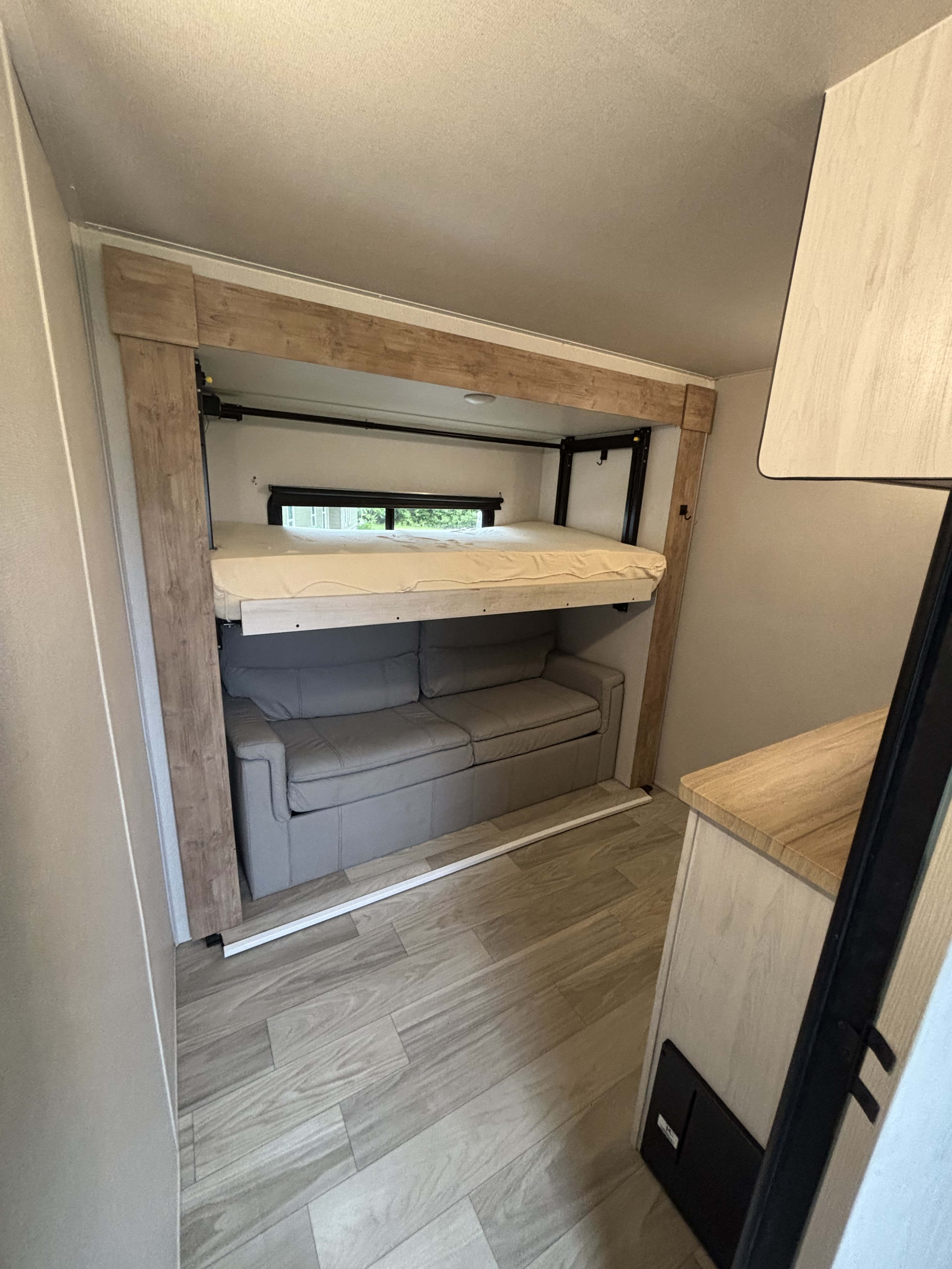 Spacious RV rental interior featuring a clever drop-down bunk bed above a comfortable sofa, maximizing sleeping and living space.. Crusader 382mbh 2023