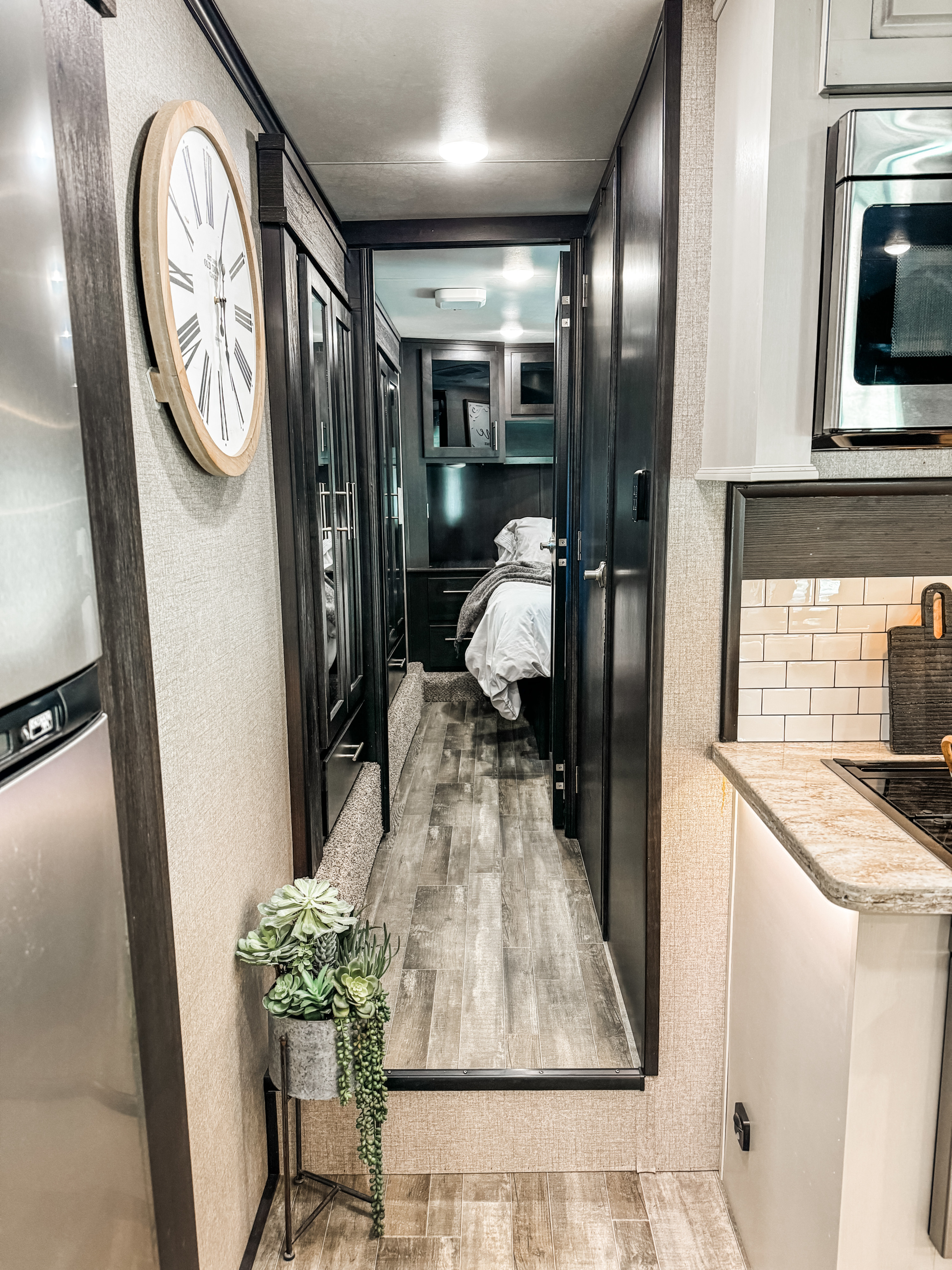 Compact and modern RV rental interior, showcasing a practical kitchen, a wood-floored hallway, and a cozy bedroom.. Jayco Seismic Toy Hauler 2021