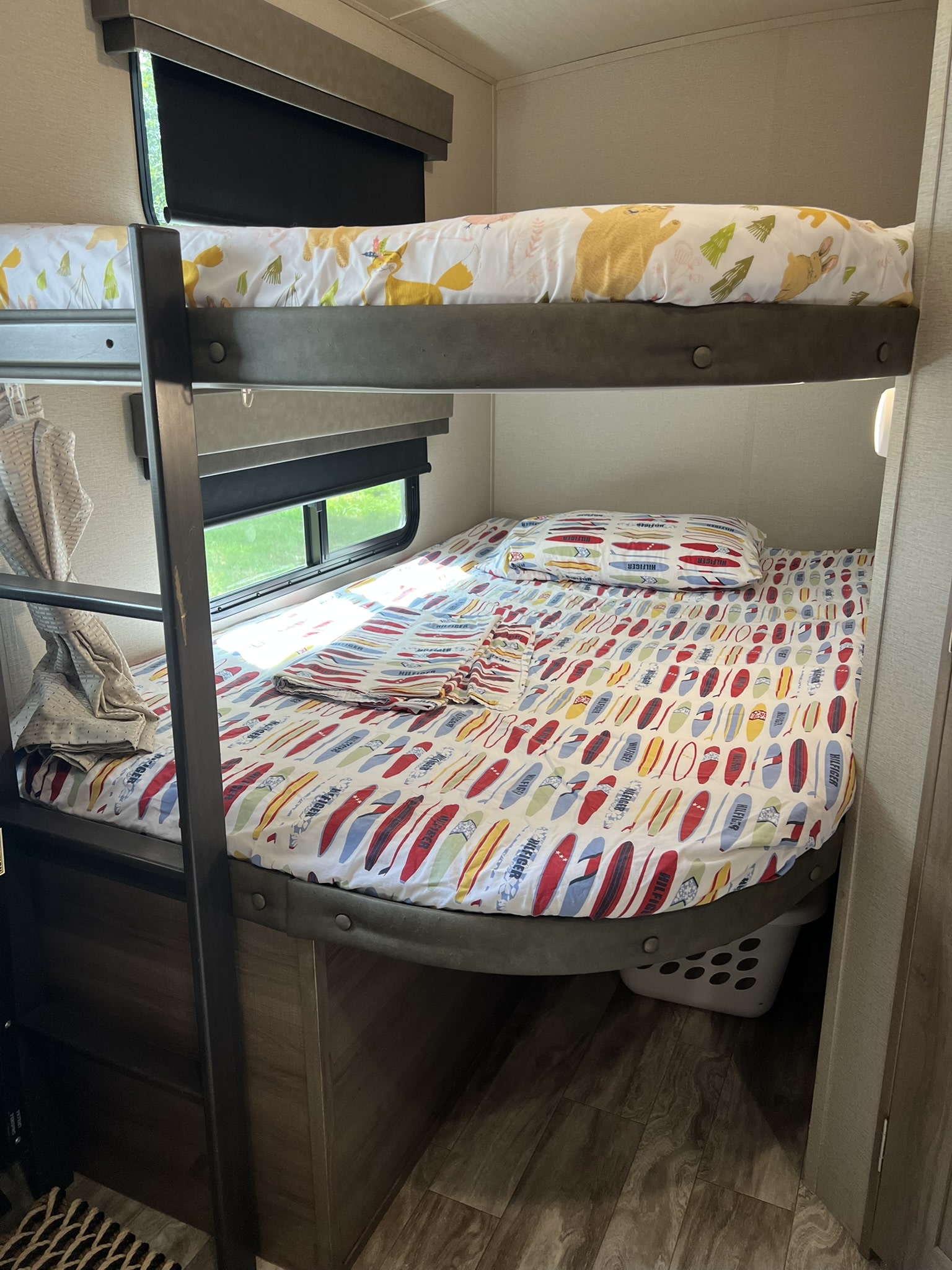 Comfortable bunk beds in an RV rental, featuring playful animal and surfboard themed bedding. Perfect for kids.. Grand Design Imagine 2021
