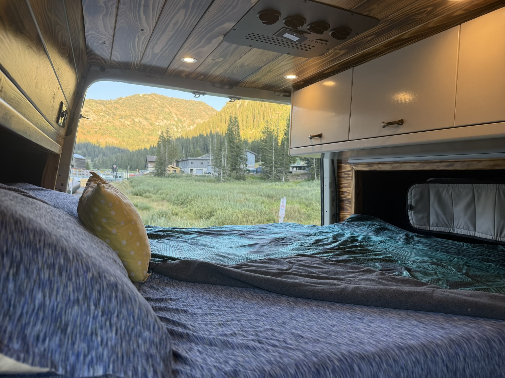 Relax in this cozy RV rental from a comfy bed, enjoying stunning mountain views and lush greenery perfect for van life camping.. Mercedes-Benz Sprinter 2019