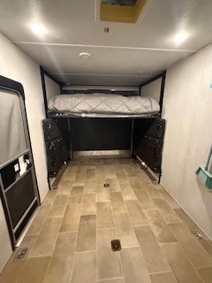 Inside this RV rental toy hauler: a spacious garage with a raised bed, durable floor, and tie-downs.. Forest River Palomino Puma XLE Toy Hauler 2020