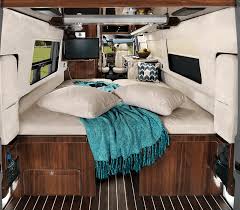 RV rental interior shows a cozy bed, side windows, and a TV. This comfortable camper van is ready for travel adventures.. Airstream Interstate 2017