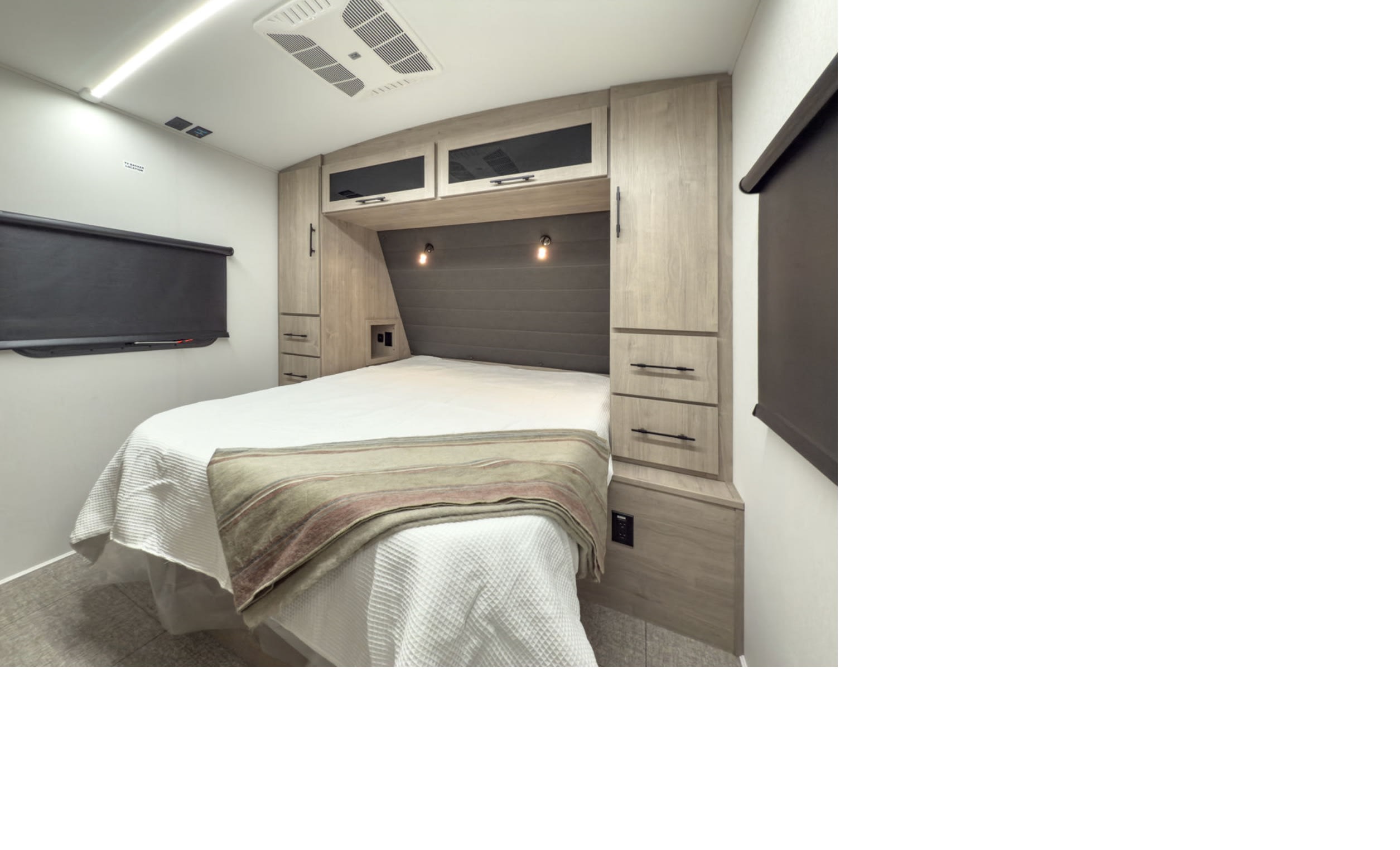 Experience comfort in this modern RV rental bedroom featuring a cozy bed, integrated storage, AC, and a concealed TV setup.. Grand Design Imagine 3100RD 2025